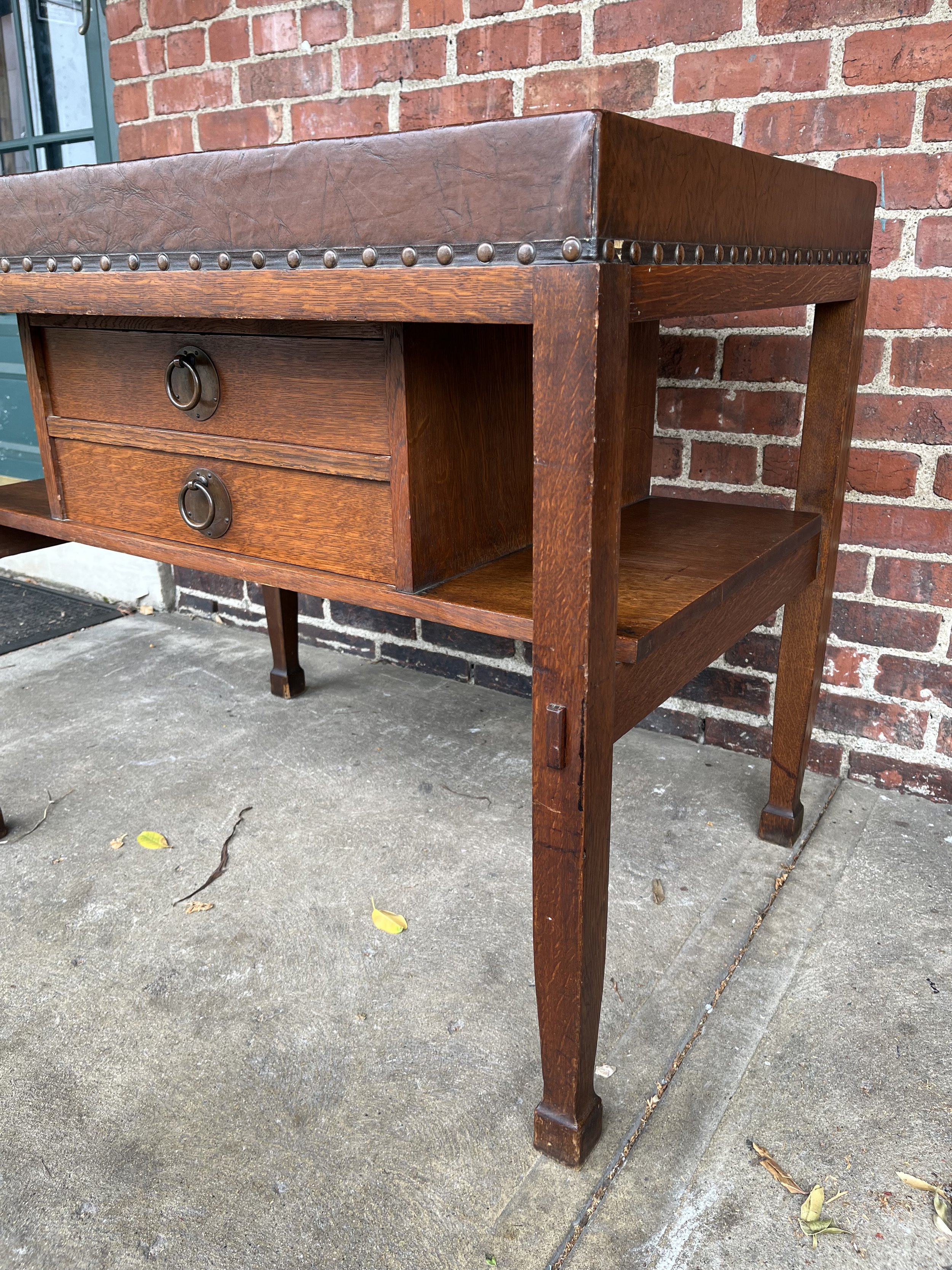 Detailed view of Stickley Brothers table's thru-tenon construction and original hardware, emphasizing its masterful craftsmanship