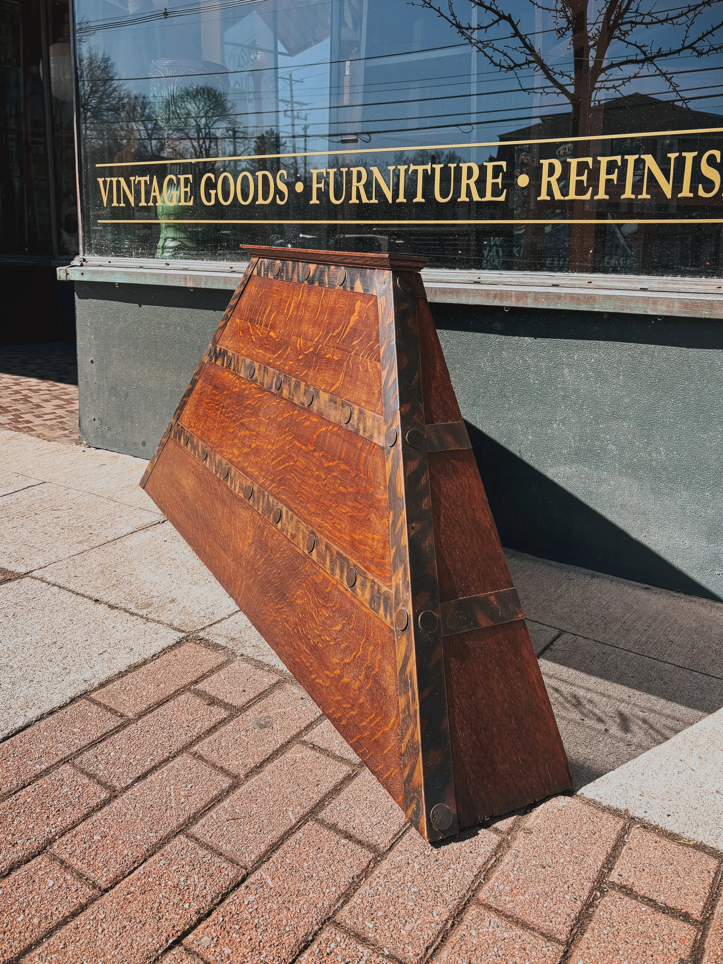 Quarter sawn oak fireplace hood with copper straps shown at angle highlighting trapezoidal Arts and Crafts design