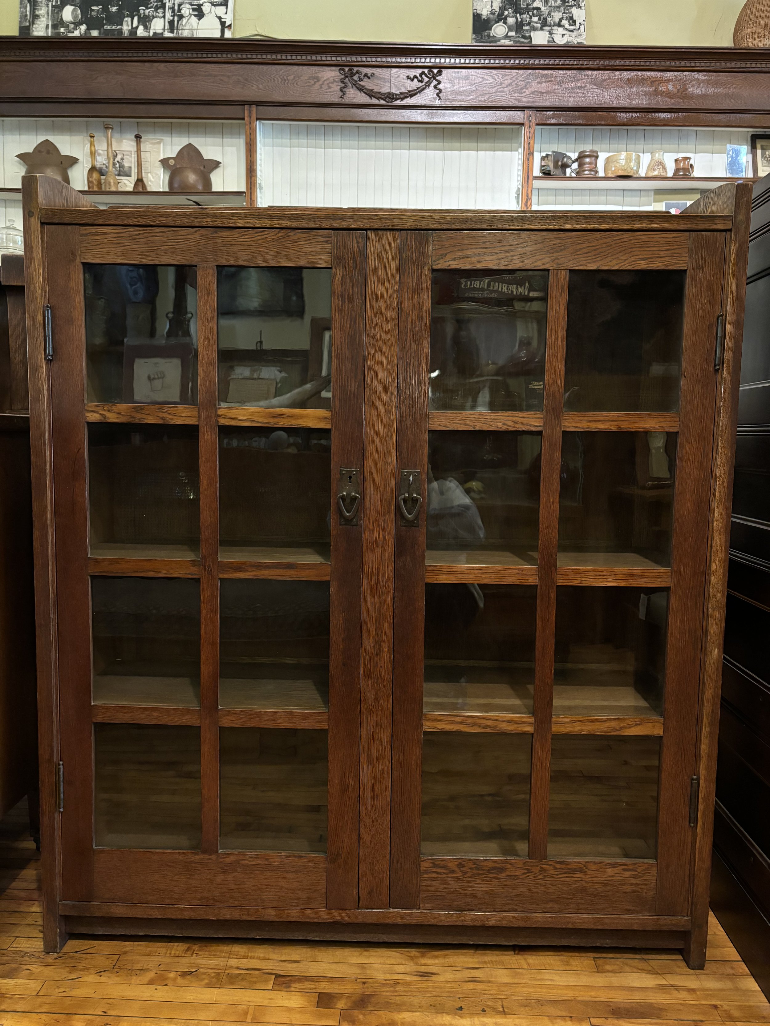 Front view of a rare Gustav Stickley double-door bookcase, featuring glass-paneled doors, original hardware, and solid oak construction. Double signed with paper label and burned-in signature.