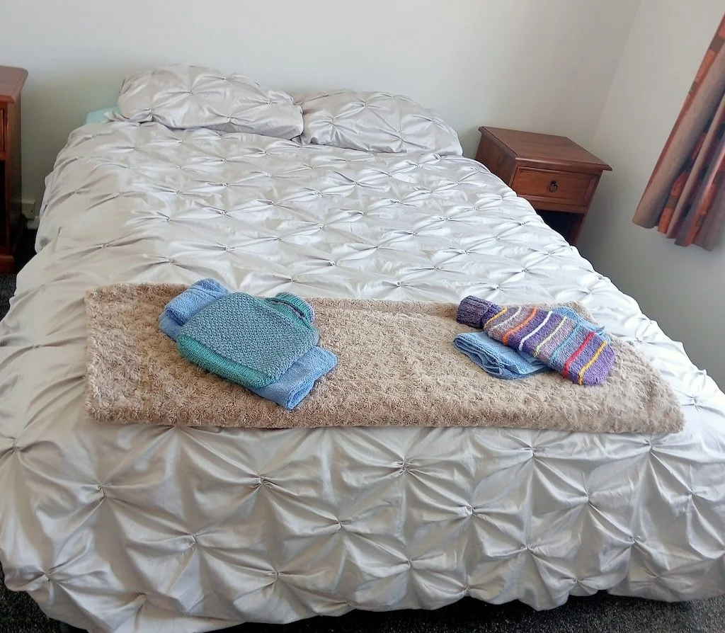 Knitted with aroha: the hot water bottle covers welcoming new neighbours home