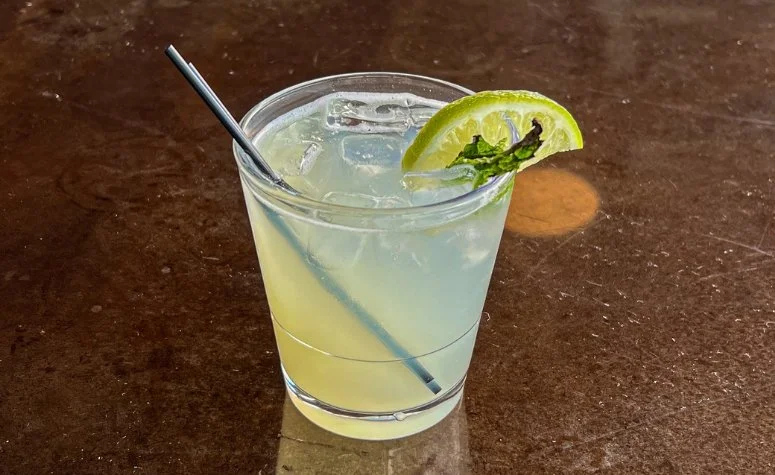 Mojito cocktail from Royal Bliss with White rum, simple syrup, lime juice, and club soda with mint leaves and a fresh lime garnish.