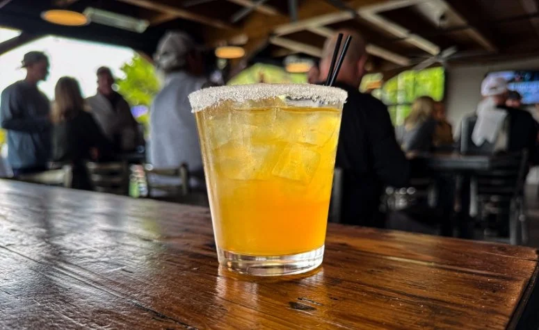 speciality cocktail from Royal Bliss Brewing called Apple Bourbon Smash with bourbon, apple cider, maple syrup, cinnamon brown sugar syrup and served in a cinnamon sugar rimmed glass