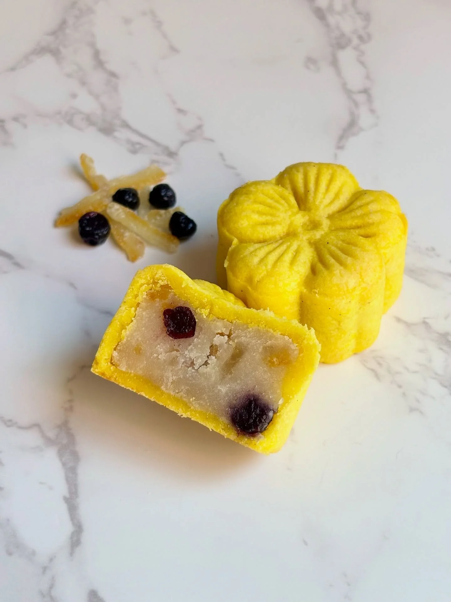 Blueberry yuzu mooncake 🫐🍋

Bright, citrusy, fruity, delicious. Made with individually peeled lima beans, real yuzu juice @theyuzuco , candied yuzu peel @kankitsulabo , sweetened dried blueberries, all wrapped in a buttery shortbread crust! 

It&rs