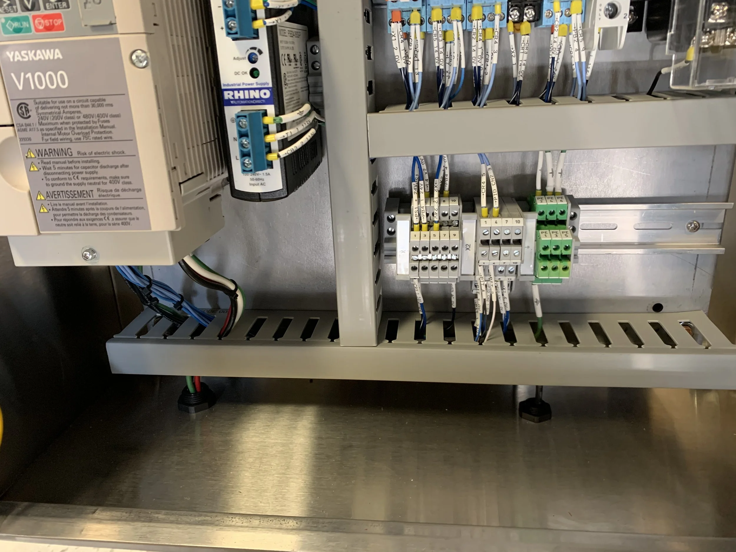 An industrial electrical control panel with wires, switches, and circuit components inside an enclosure.