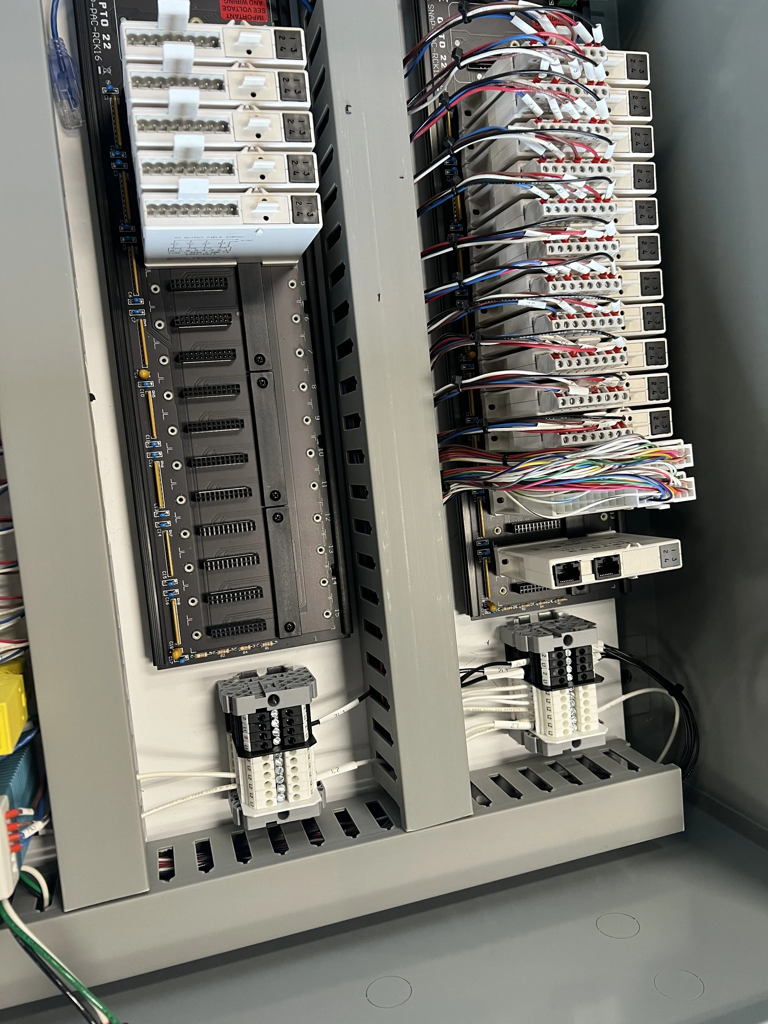 An industrial electrical control panel with circuit breakers, wiring, and terminal blocks.