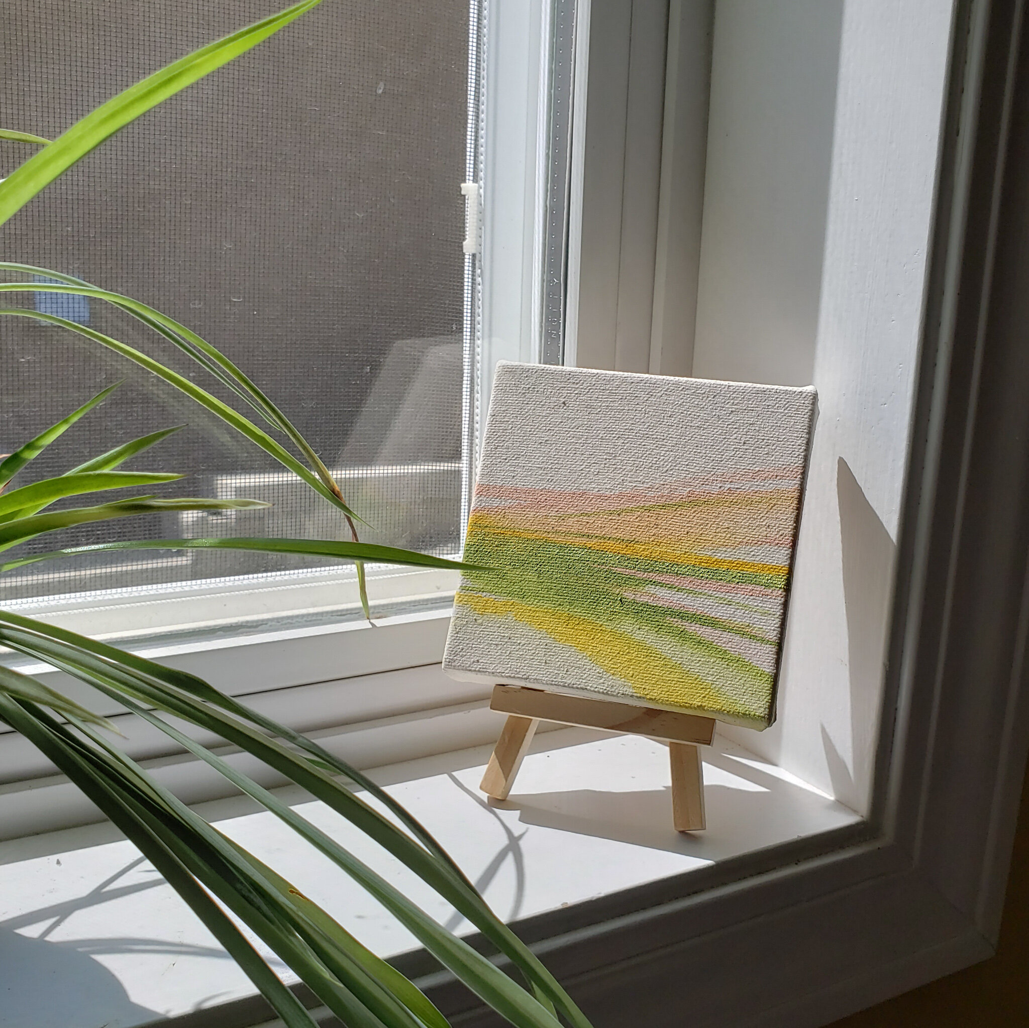 mini abstract landscape painting in sunny windowsill