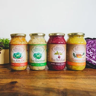 Product Label Design Perth. Sauerkraut Label Design. Health Food Label Design. Four jars of raw kimchi and kraut on a wooden surface, with a purple cabbage on the side.