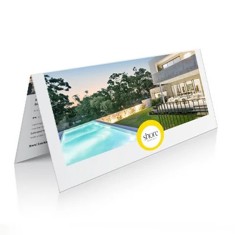 A photo card with an image of a modern house and a swimming pool, with a yellow circle logo that says 'shore'.