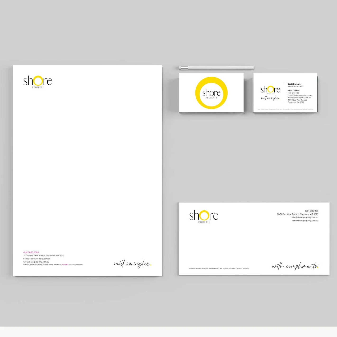Branding stationery set for Shore Property, including letterhead, business cards, and a notepad with a white and yellow logo design, displayed on a gray background.