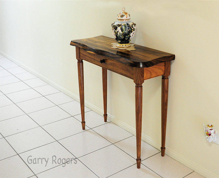The Monkey Pod and Blackwood Hall table. This lovely little table started out as a wavy edged coffee table. The original coffee table was a present to my client from her late husband. Together with her daughter they commissioned me to turn it into a