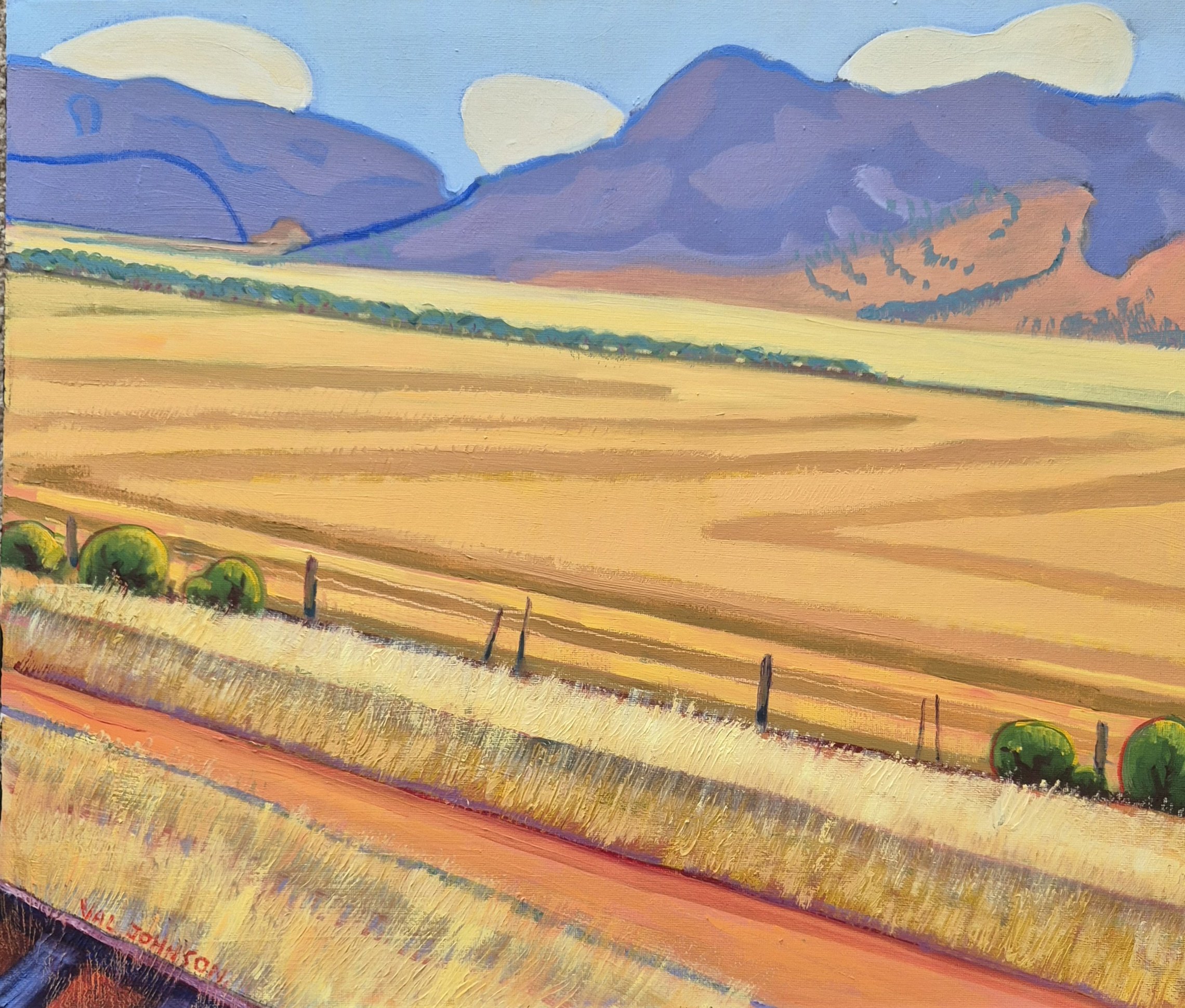 Purple mountains with dry grassy fields in the forground