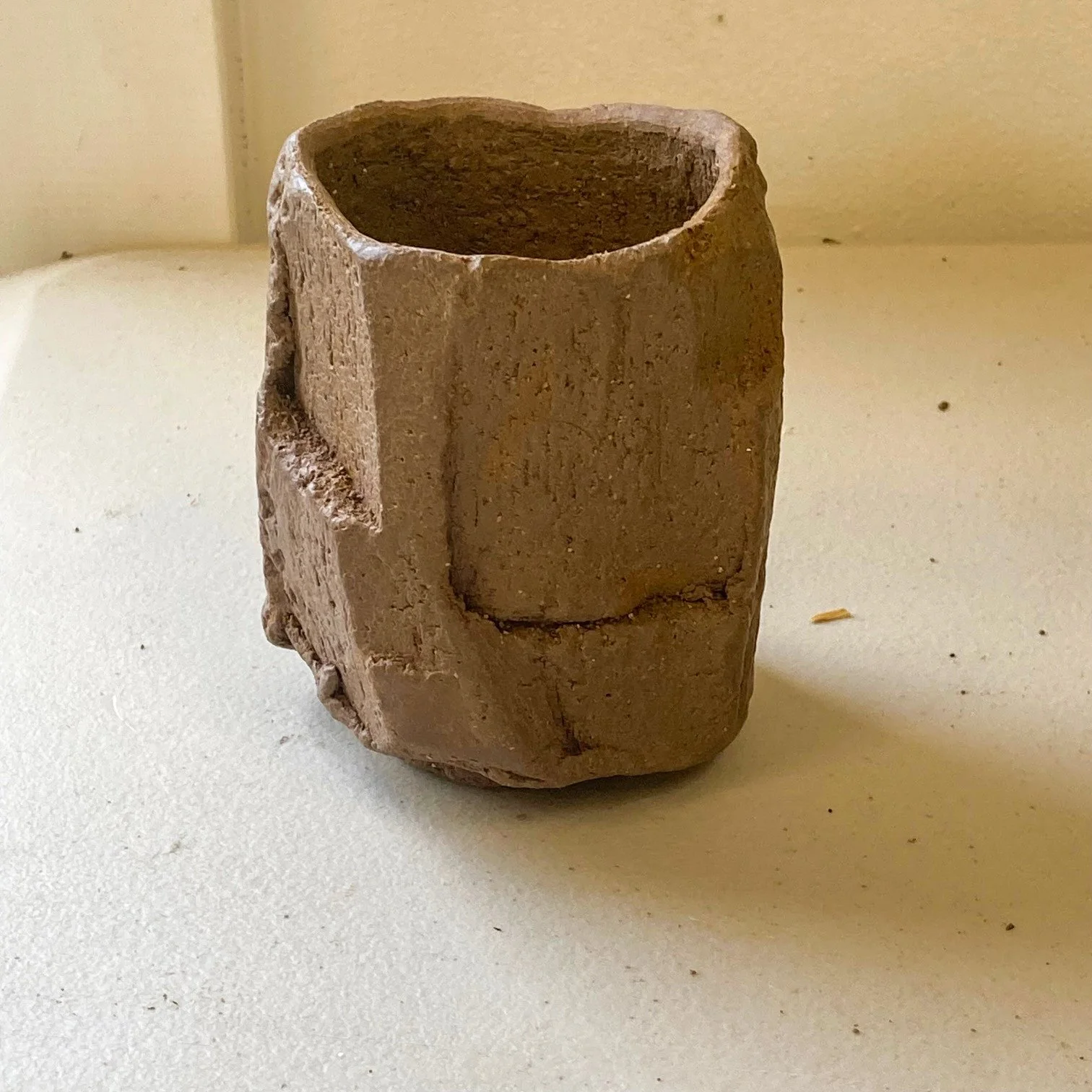 Small ceramic tumbler with an angular natural texture. 
