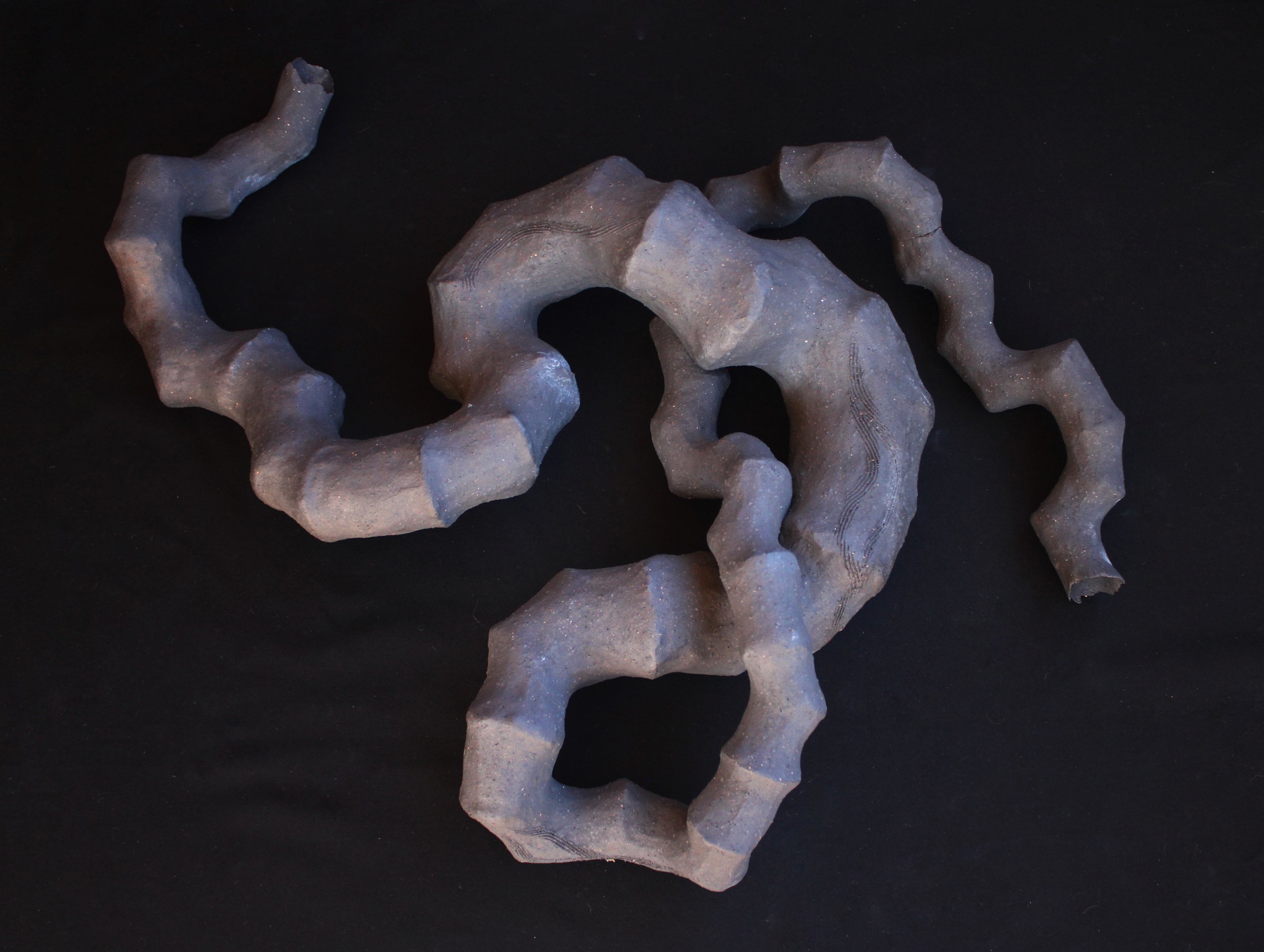 A long curvy ceramic form twisting into a knot shape