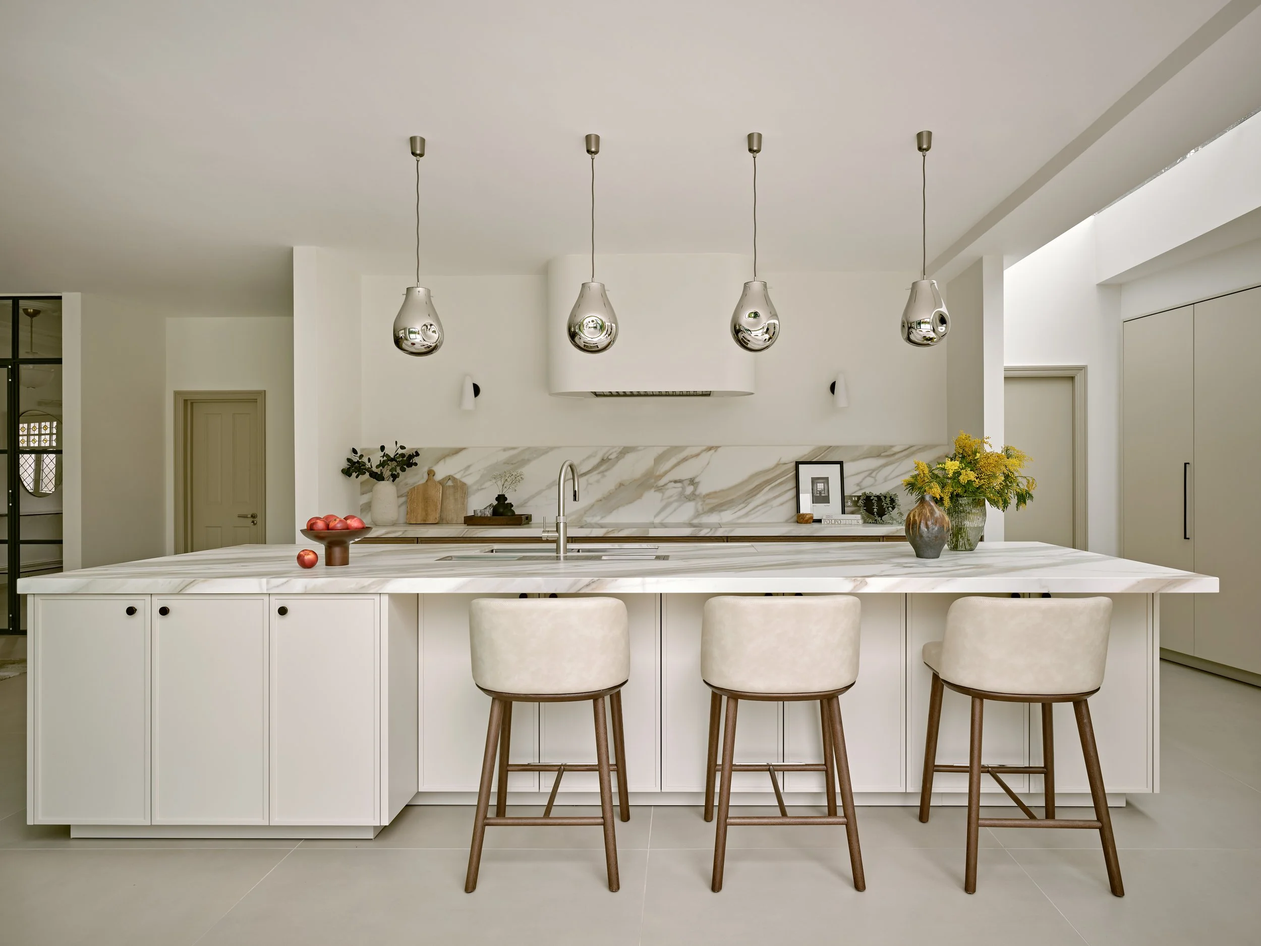 Modern white and wood kitchen with Sapienstone island, pendant lighting, and minimalist cabinetry in a bright, contemporary interior.