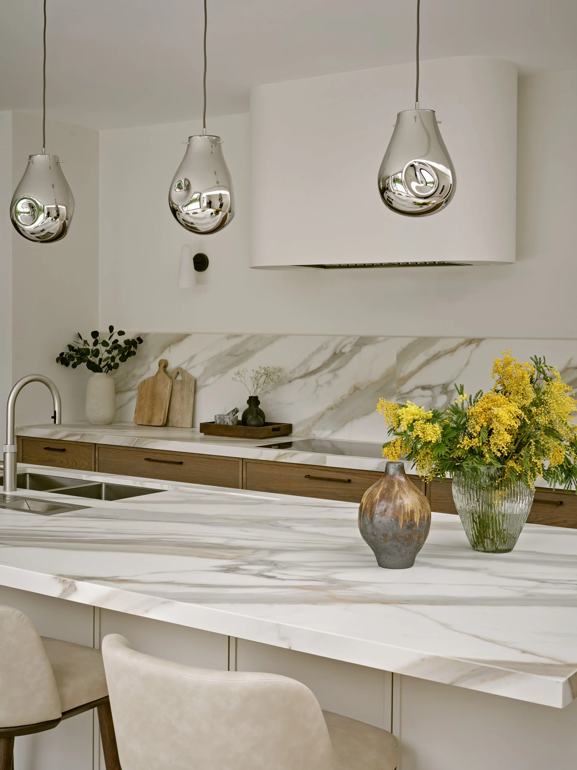 Painted maple micro shaker island, Sapienstone worksurface with 50mm mitred edge. Contemporary pendents and bespoke curved extractor chimney. 