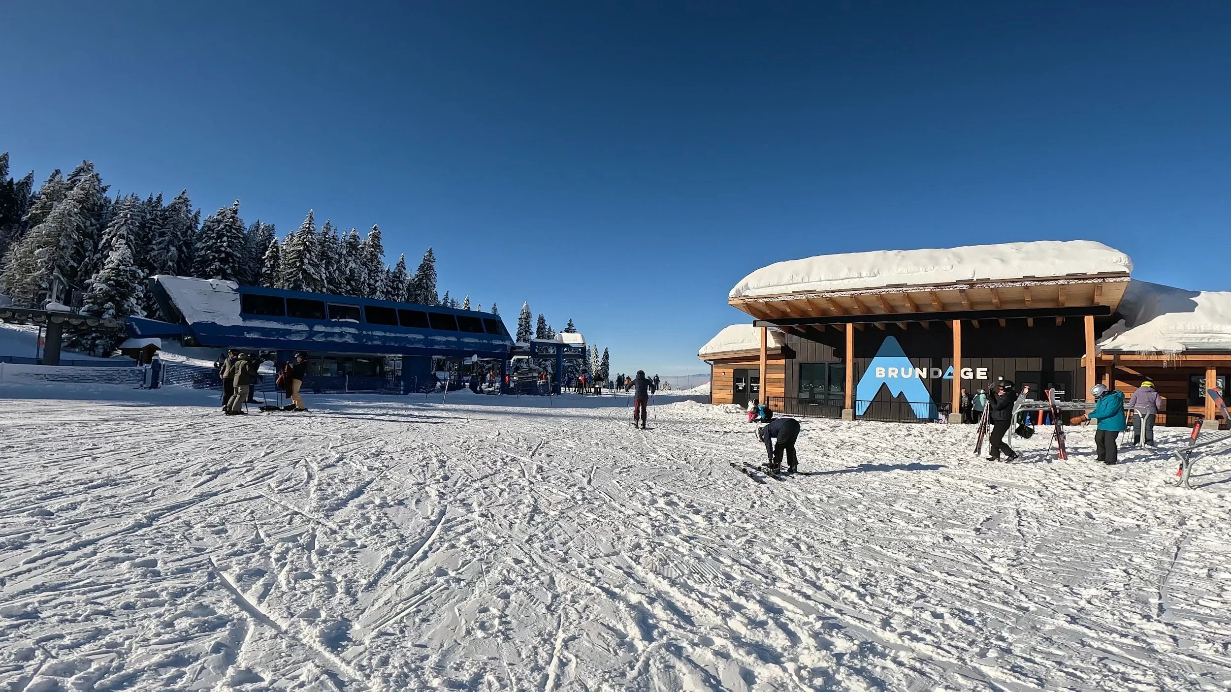 Skiers in the base area at Brundage near the lodge and lift terminal