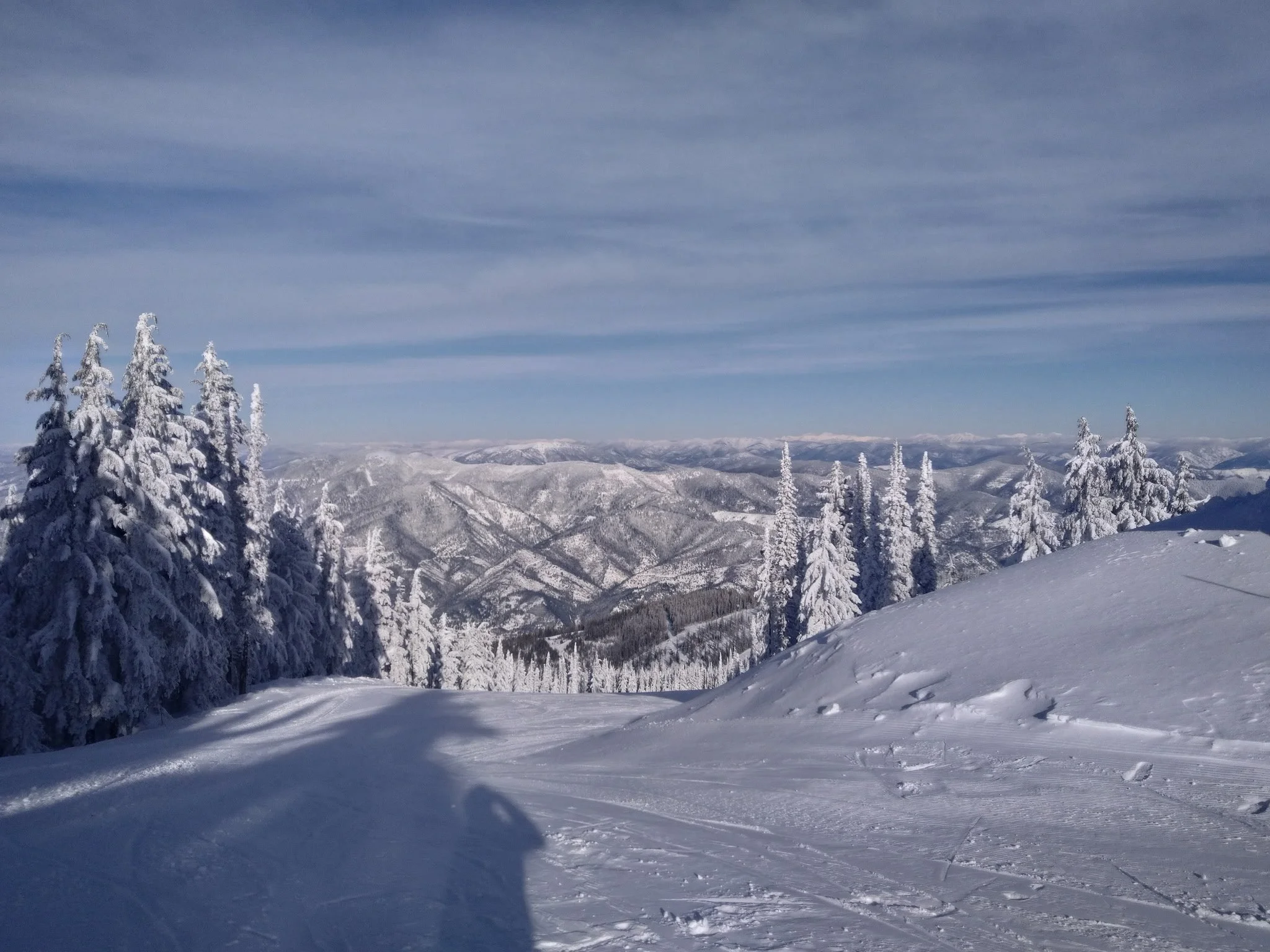 Snow-covered evergreens and mountain ridges seen from the top of Silver Mountain