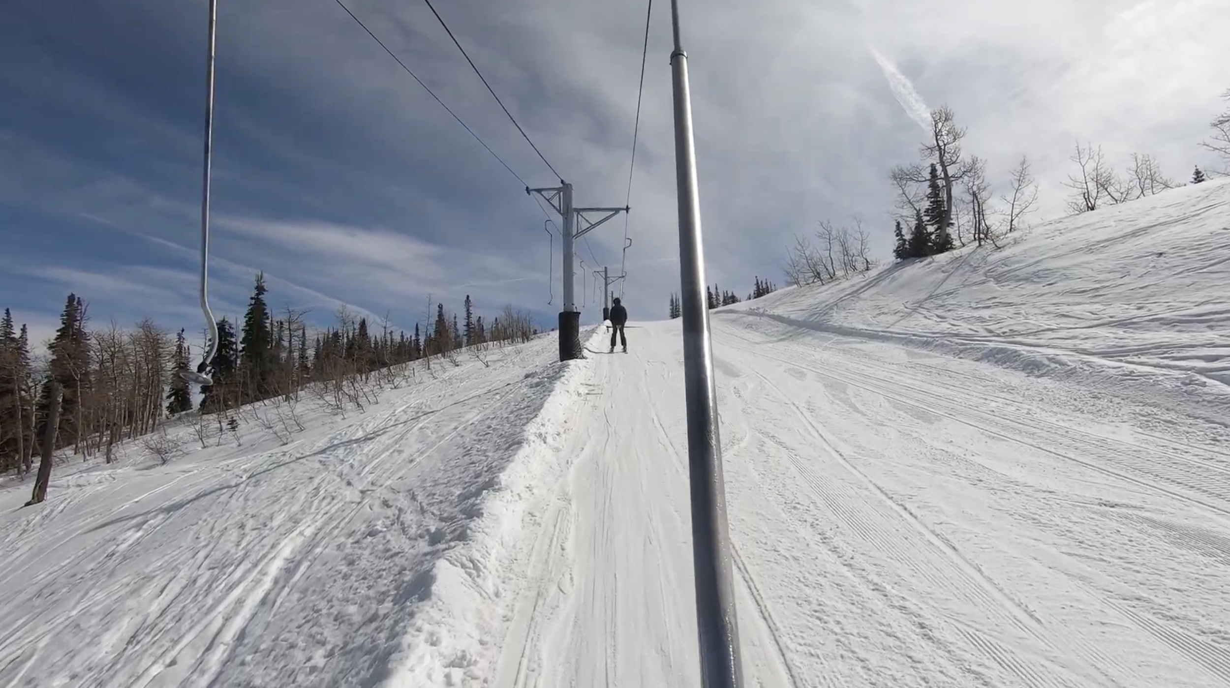 Riding up a poma lift on a sunny day at Powder Mountain ski resort, Utah