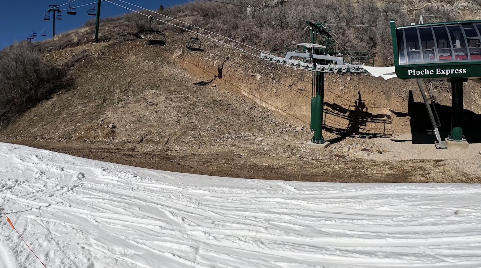 A closed ski lift goes up a hillside of bare dirt and rocks at Deer Valley ski resort, Utah
