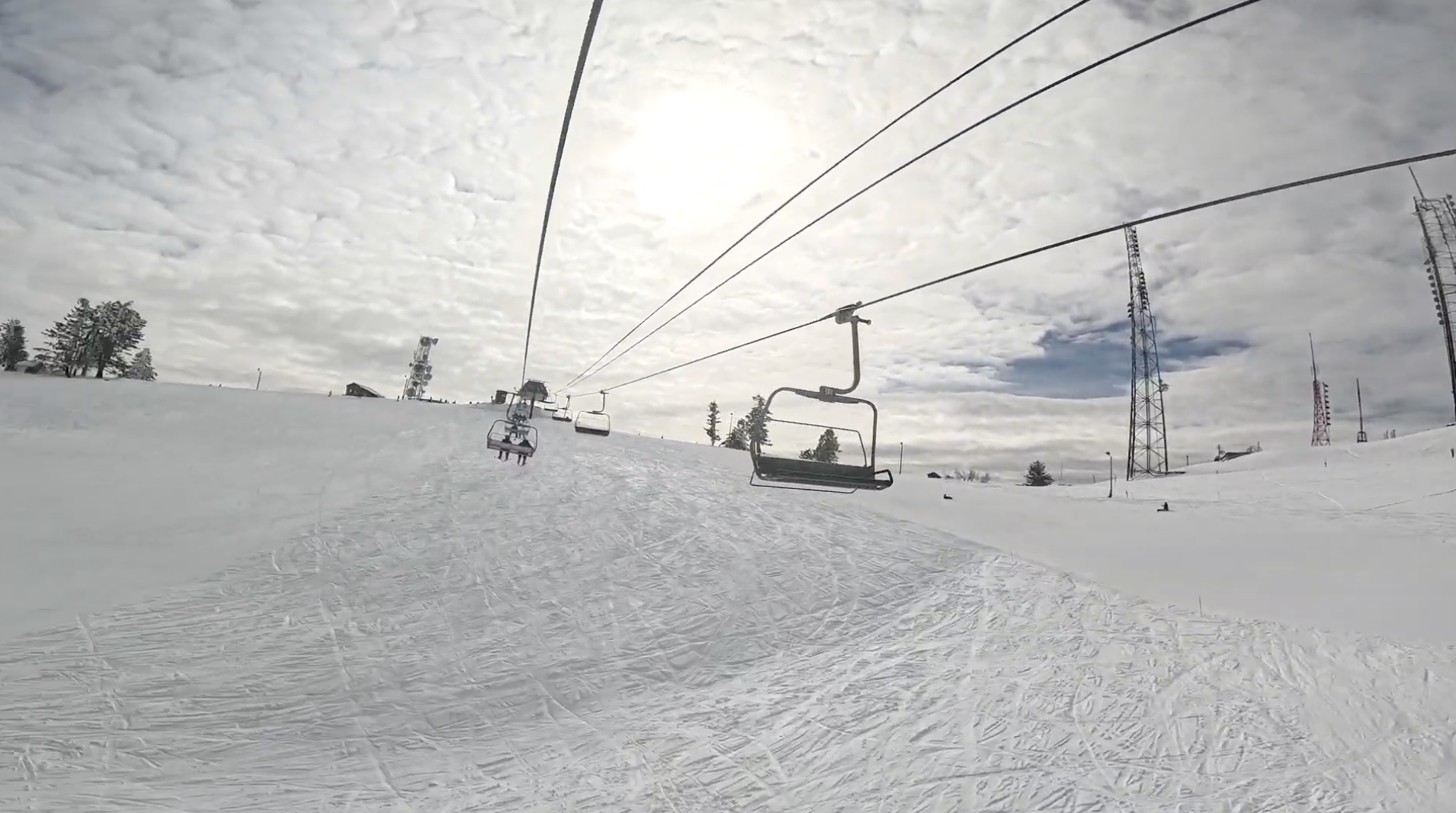 Riding up a chairlift over an open snowfield with radio towers to the right at Bogus Basin ski resort, Idaho