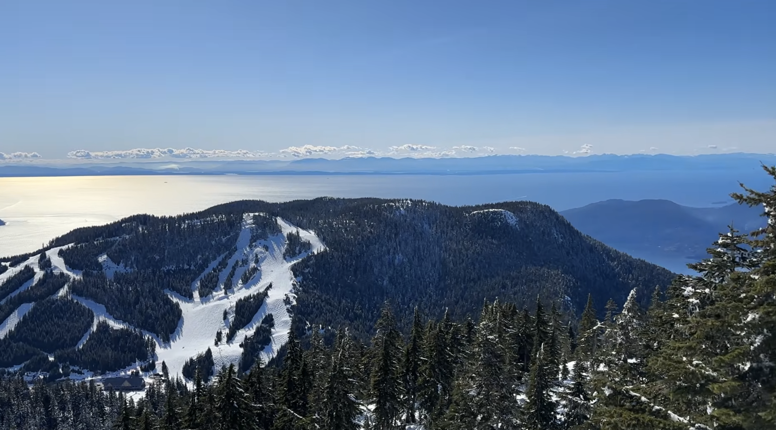 Beautiful panoramic view of the sea with a snowy ski mountain in the foreground at Cypress Mountain, British Columbia
