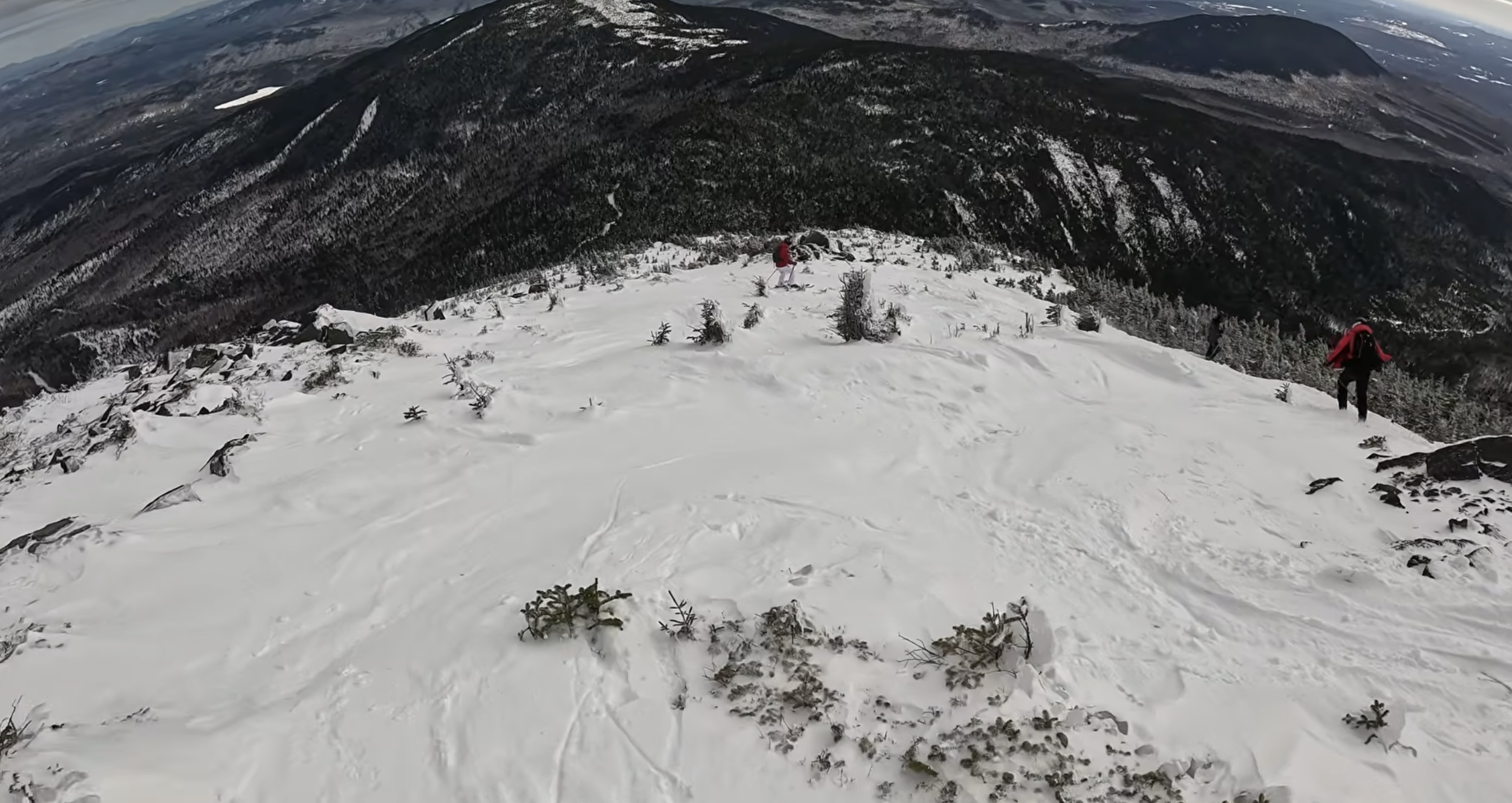 Skiing down a steep slope with low scattered undergrowth at Sugarloaf ski resort, Maine