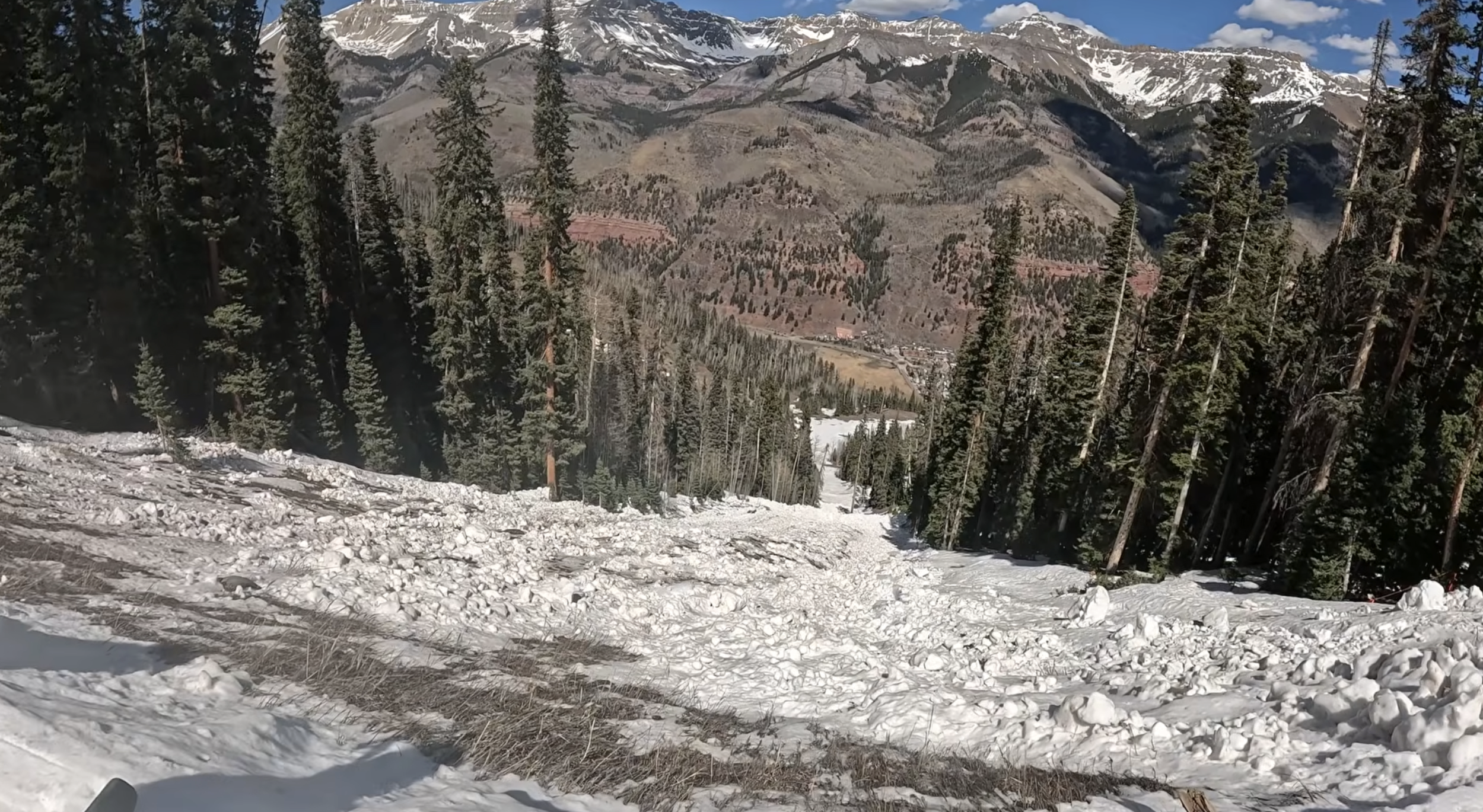 Looking down a steep slope covered by avalanche debris at Telluride ski resort, CO