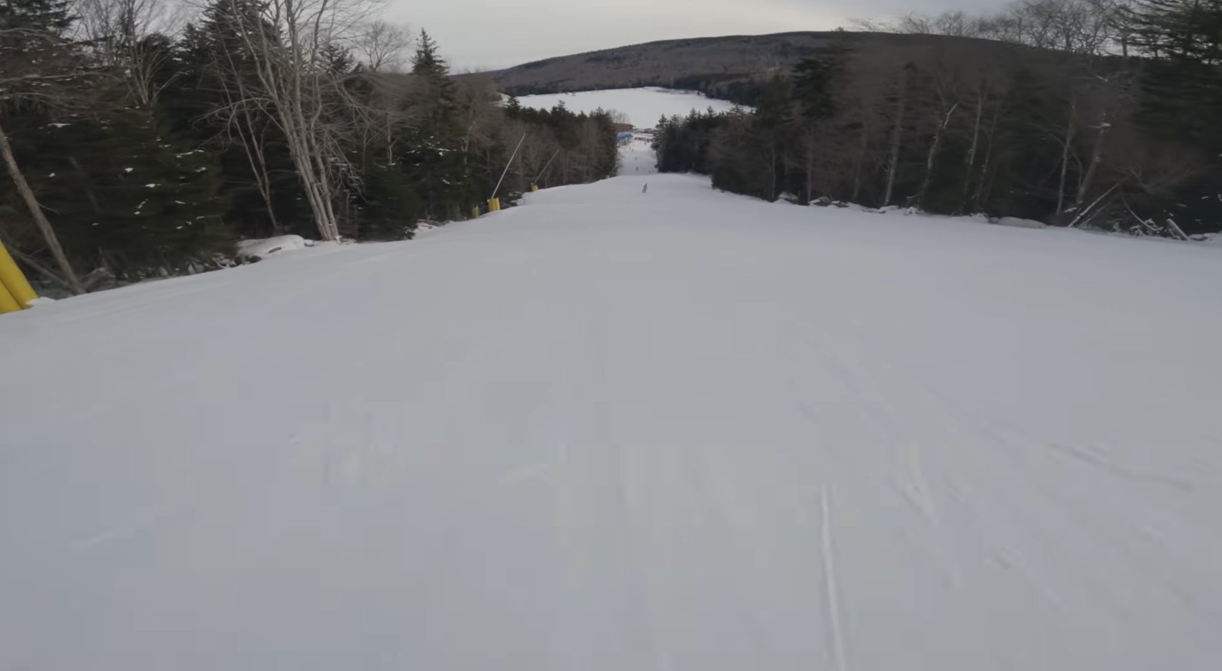 Skiing down a slope toward a frozen lake at Snowshoe, West Virginia