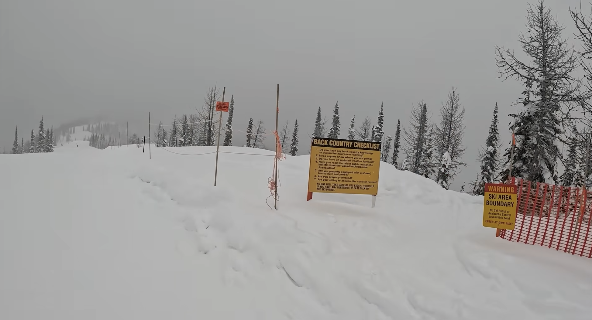 A warning sign and fence at the boundary of Whitewater ski resort, British Columbia