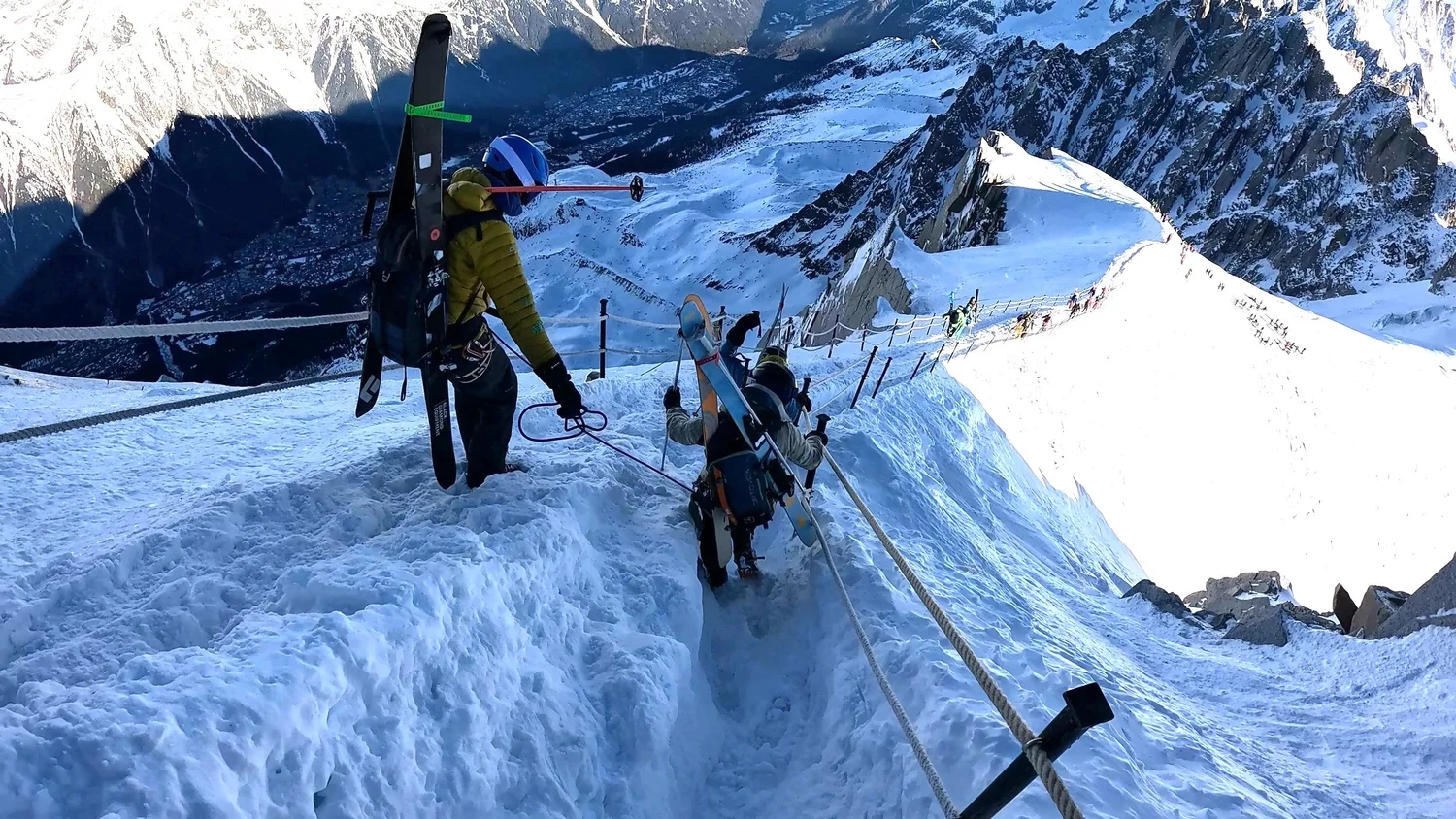 Skiers walking down the roped ridge from the Aiguille du Midi