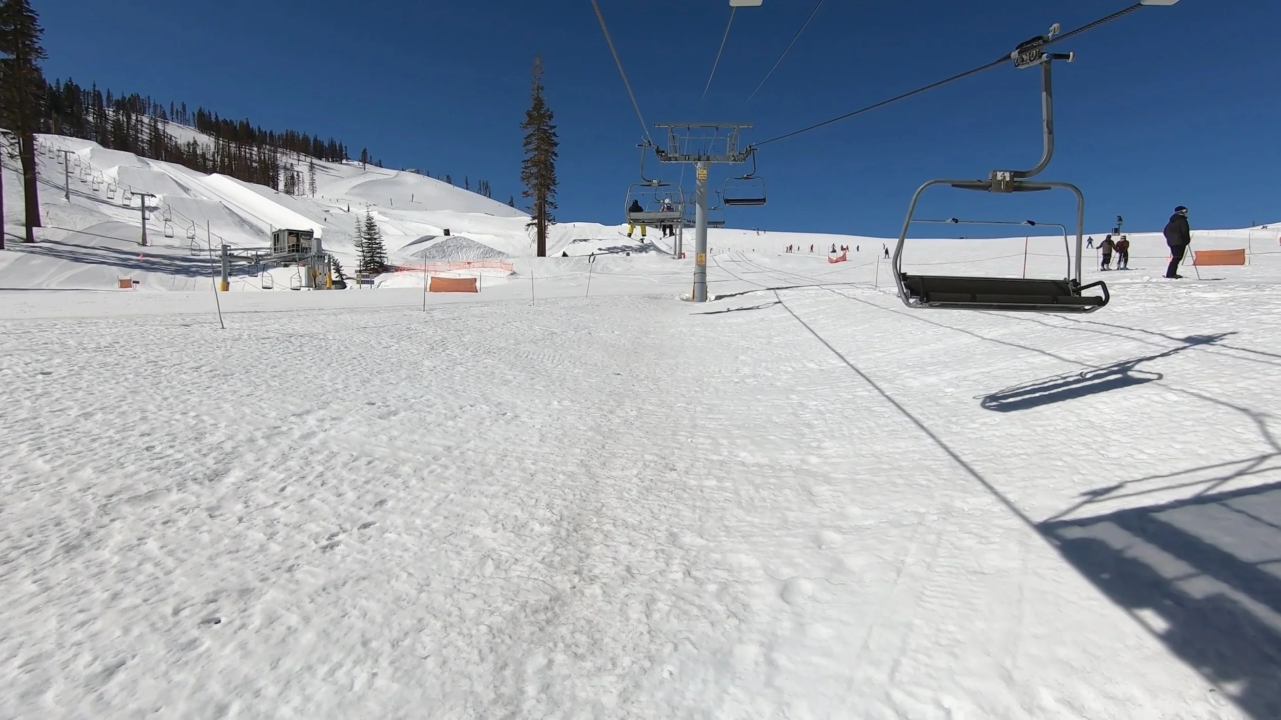Ride up a chairlift on a sunny day at Sierra-at-Tahoe ski resort.