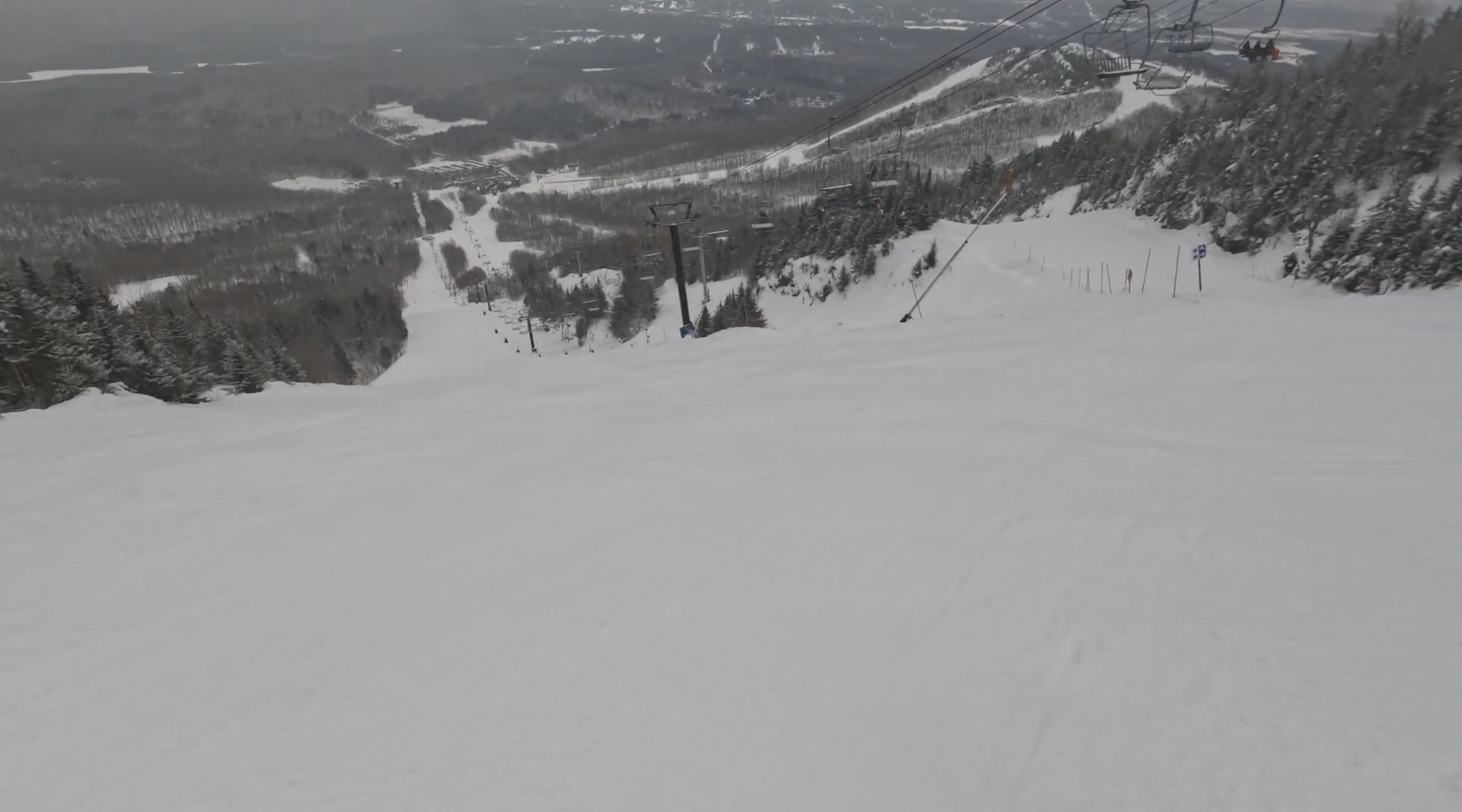 Looking down a steep ski slope with chairlifts running up it at Mont Orford, Quebec