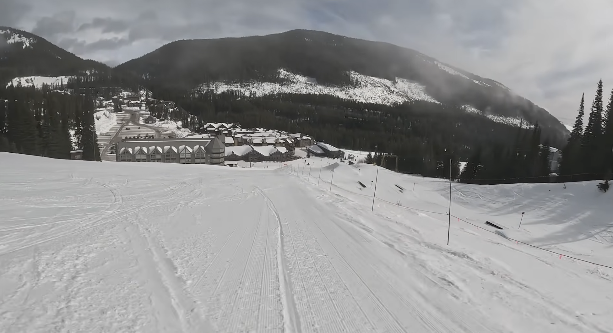 A view down a ski slope with hotels and buildings at the bottom, Apex, BC, Canada