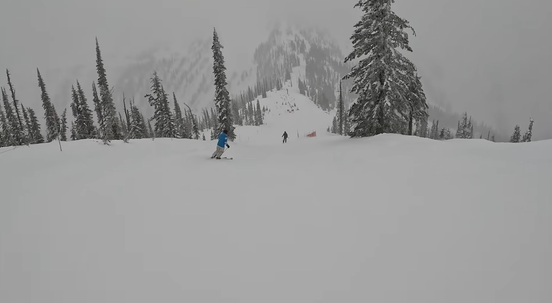 Skiing down a slope at Whitewater ski resort, British Columbia on a foggy day
