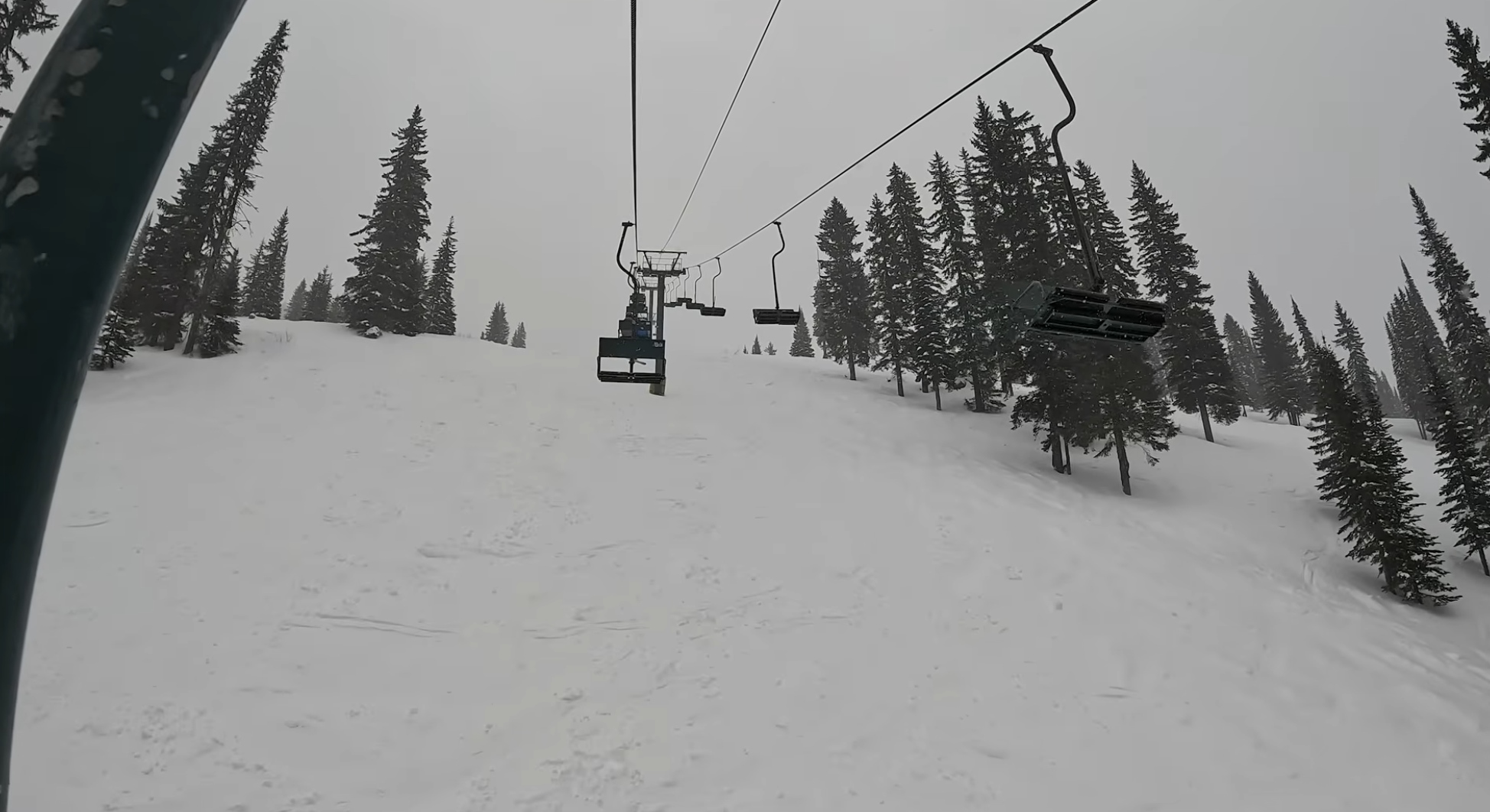 Riding up an old chairlift on a snowy day at Whitewater ski resort, British Columbia