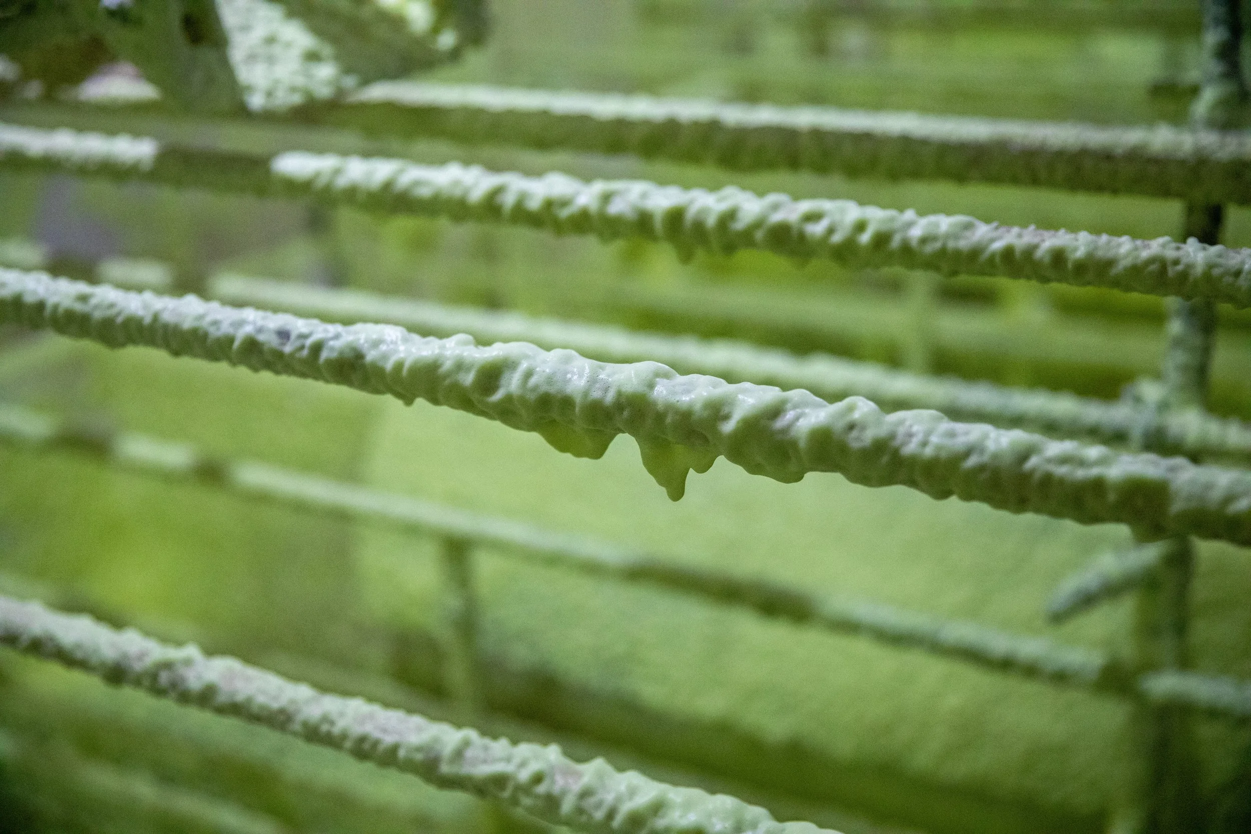 Metal bars coated with thick VisiFoam, demonstrating its high-foaming cling for effective degreasing.