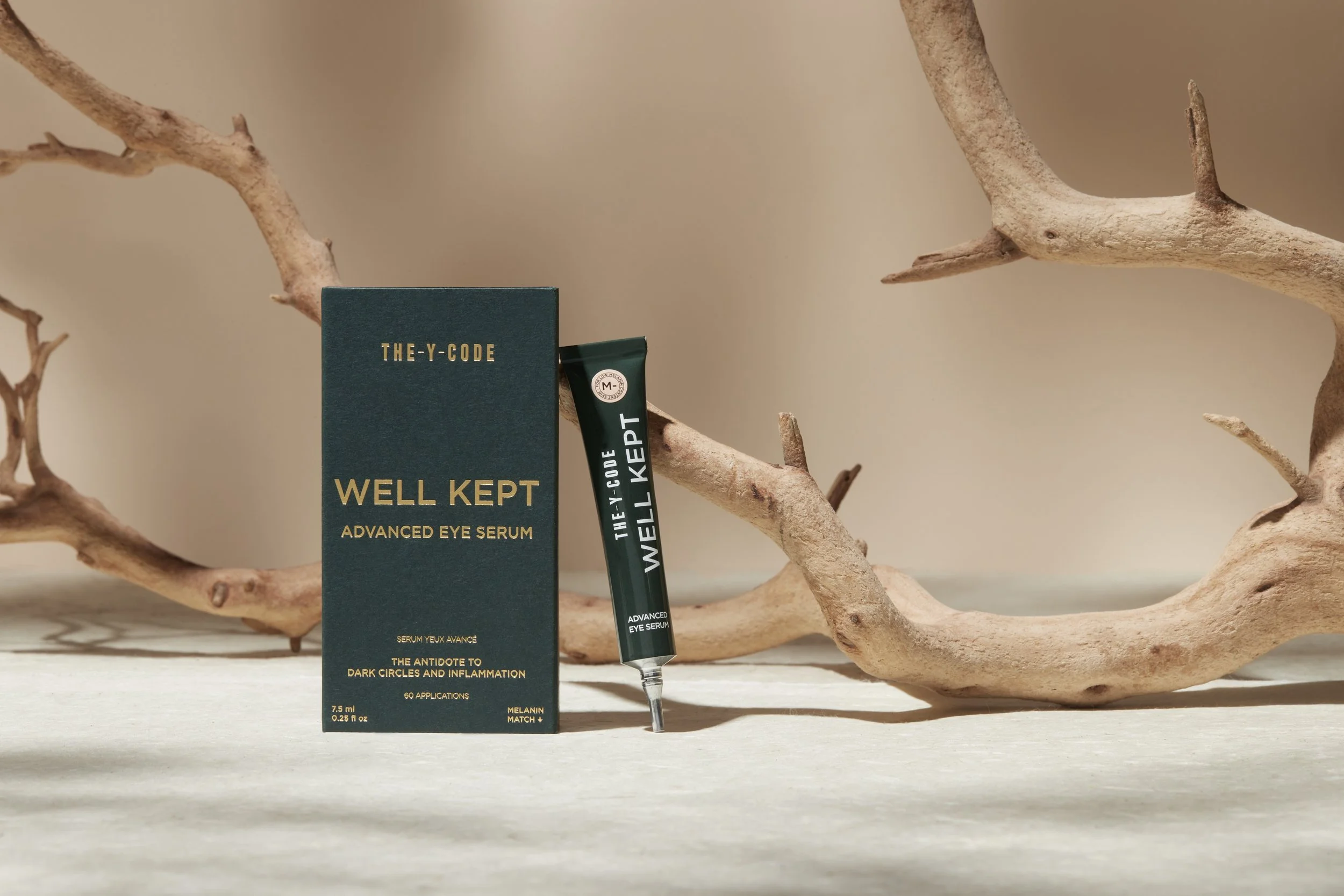 A box and tube of Well Kept advanced eye serum, with a dried orange branch in the background, on a light surface. Los Angeles beauty product photography.