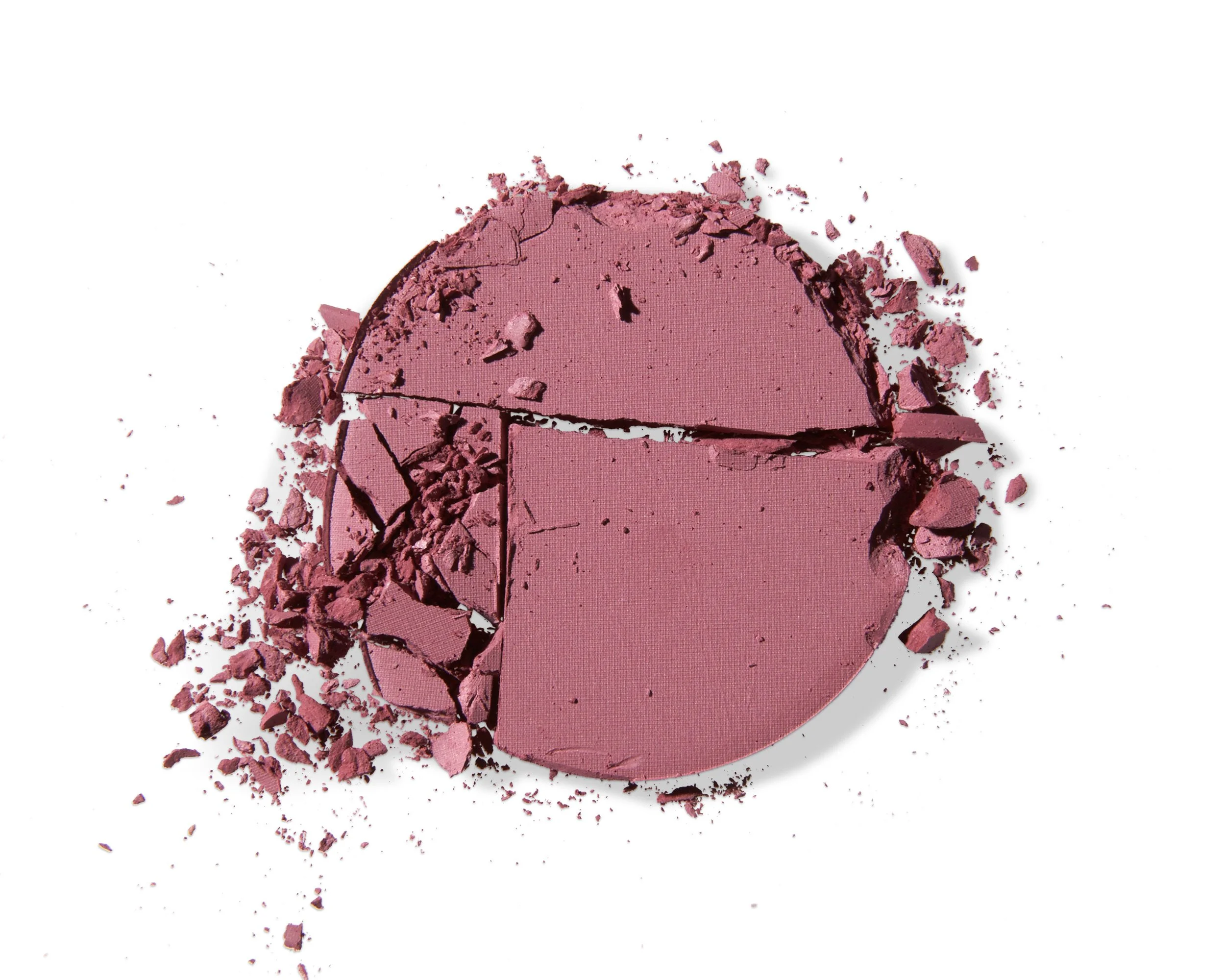 Broken pink blush compact with shattered pieces scattered around on a white background.
Los Angeles beauty product photography.