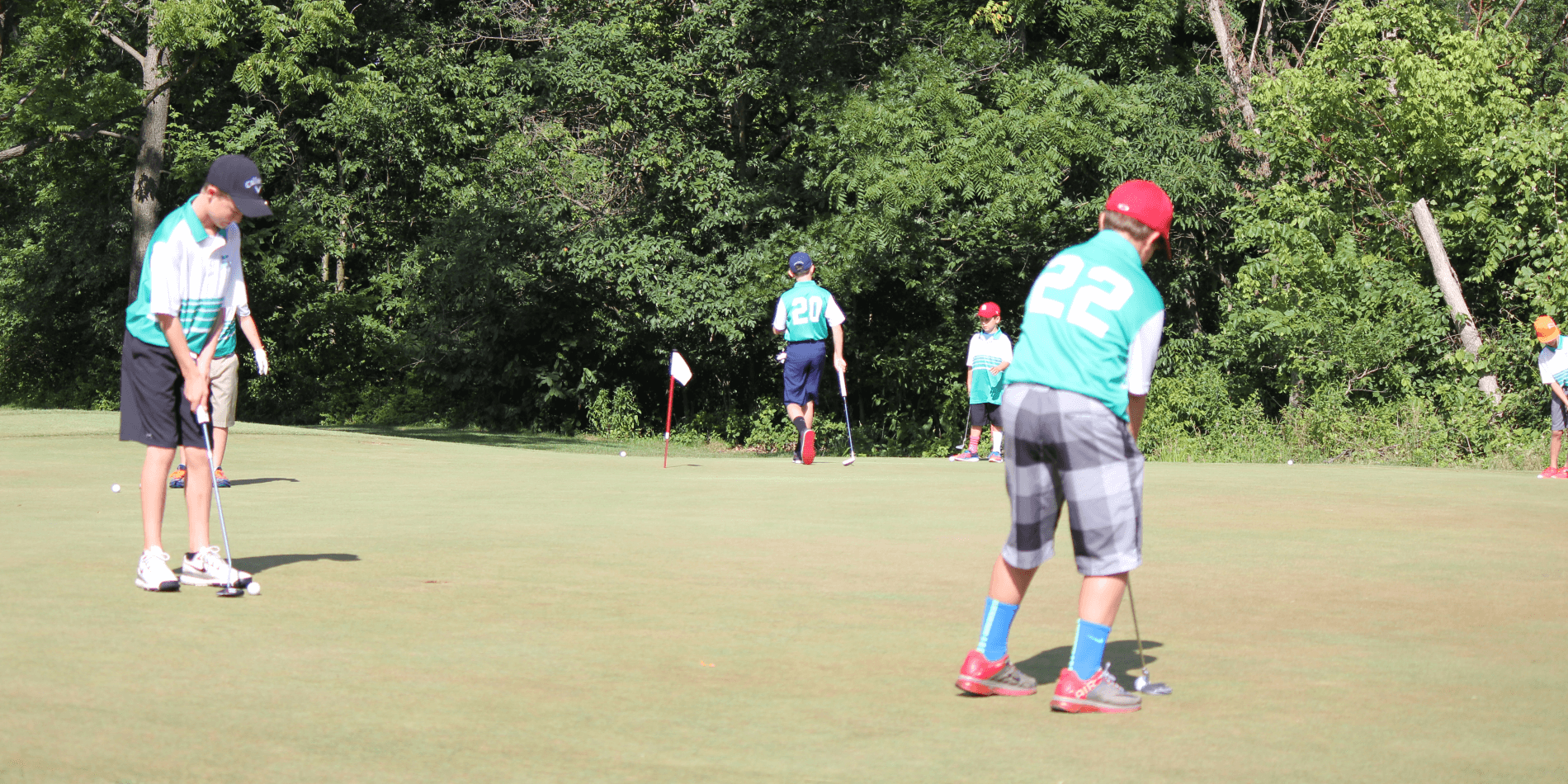 Junior golfers learning together on a practice green