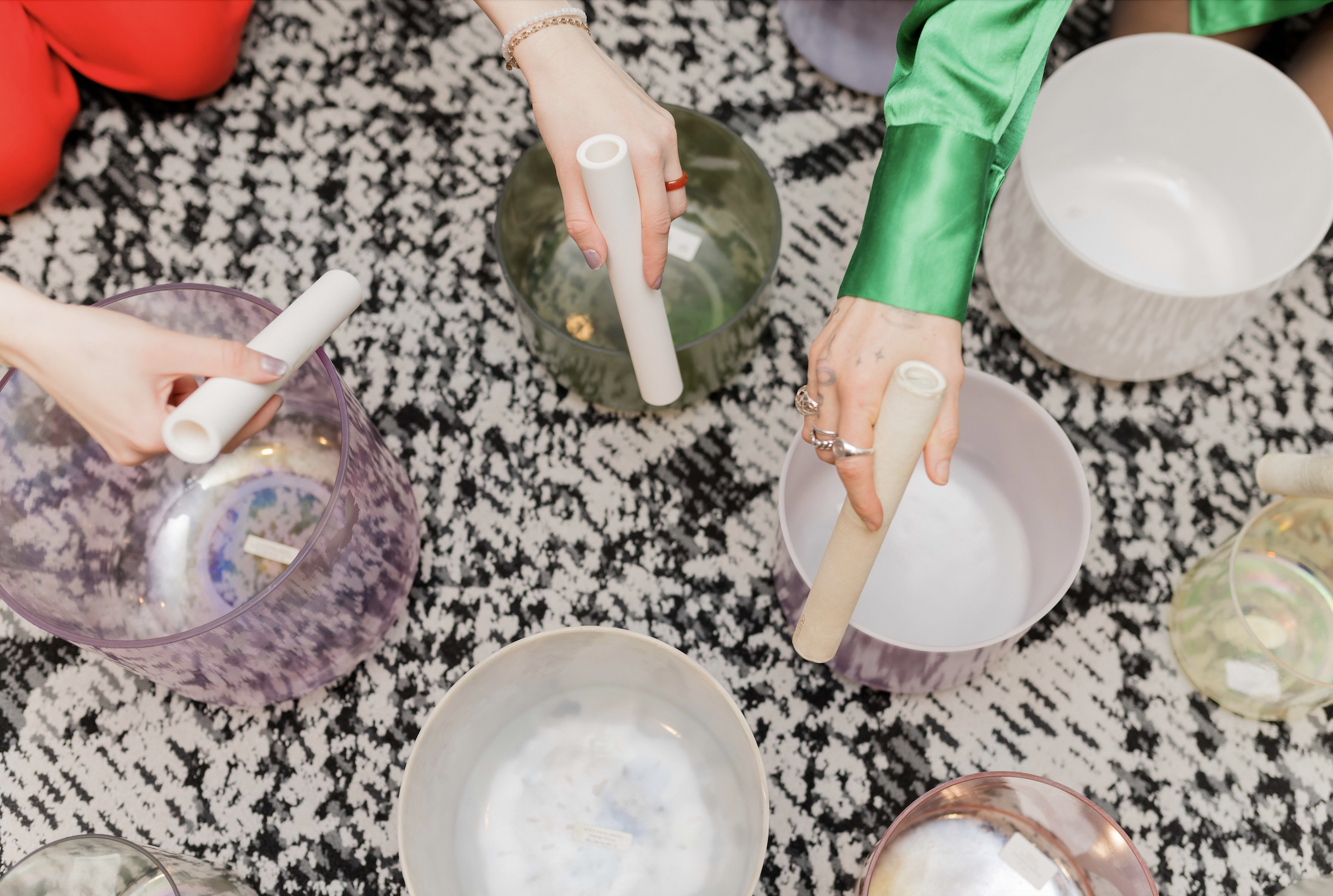 Hands Playing Crystal Tones Alchemy Bowls on Patterned Carpet