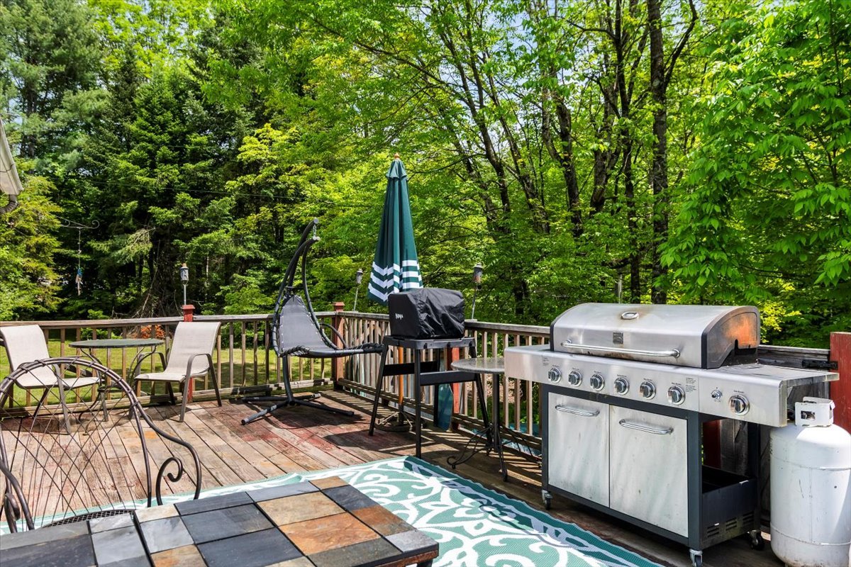 Large deck with gripp, smoker, seating and outdoor rug perfect for enjoying Vermont's beauty on Shaftsbury house for sale.