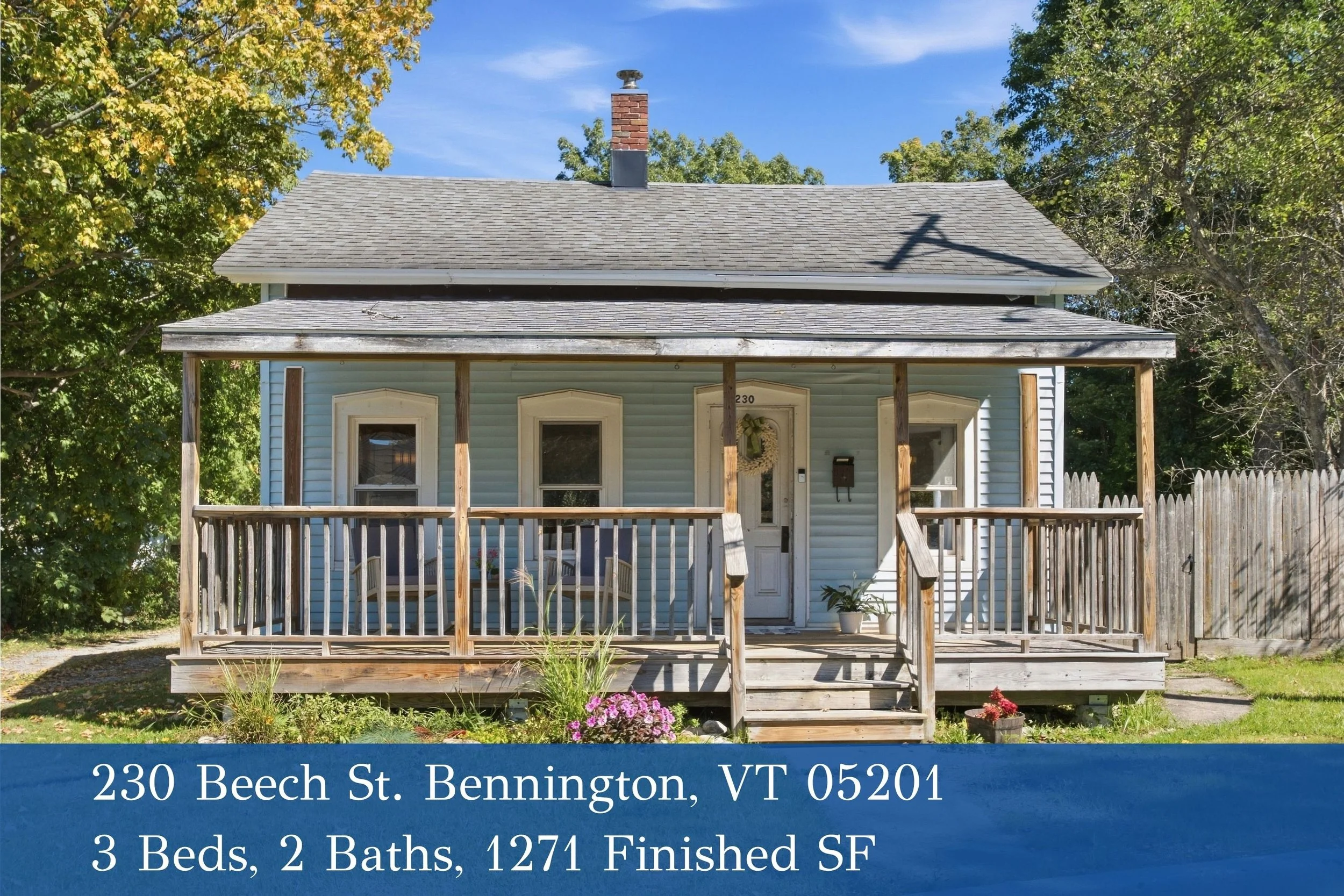 A small blue house with a front porch, decorated with a wreath on the door, and surrounded by green trees. The house has a wooden fence and a lawn with some pink flowers. There is a chimney on the roof, and shadows of utility lines are cast on the roof. The bottom overlay provides the address 230 Beech St., Bennington, VT 05201, and details about a property listing, including 3 bedrooms, 2 bathrooms, and 1271 finished square feet.