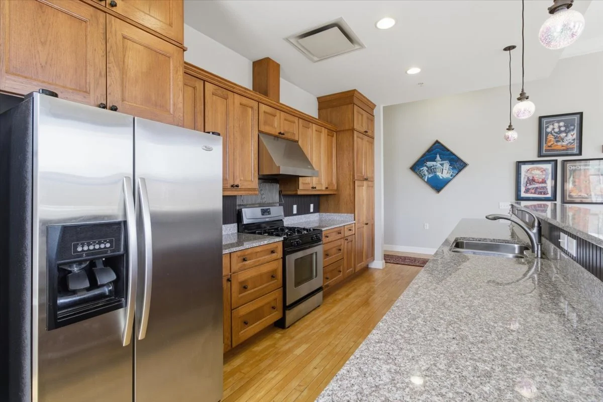 Kitchen at 113 South St. #302 a downtown condo for sale featuring granite countertops, stainless steel appliances and lots of sturdy, handsome cabinetry.