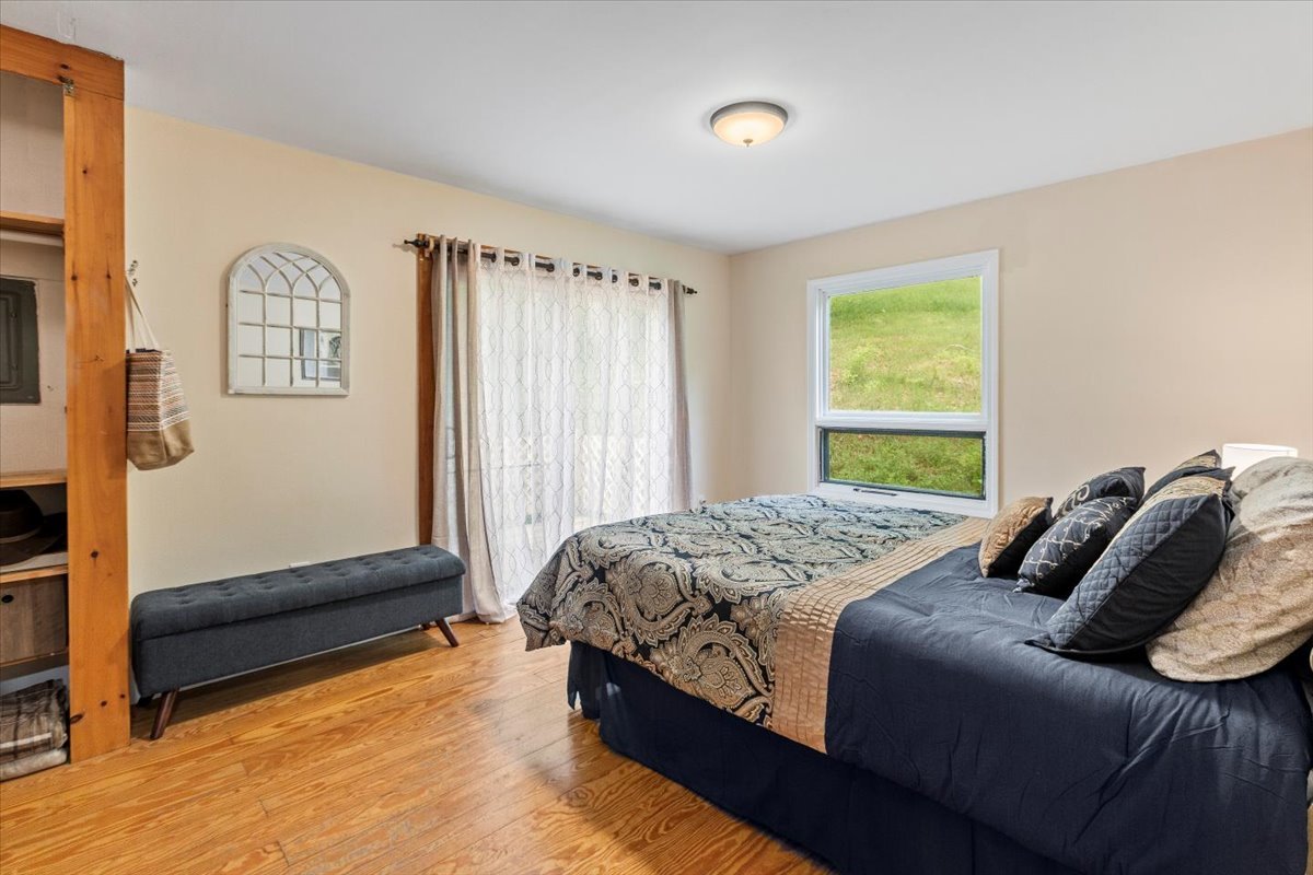 Large bedroom with windows and wood floors.