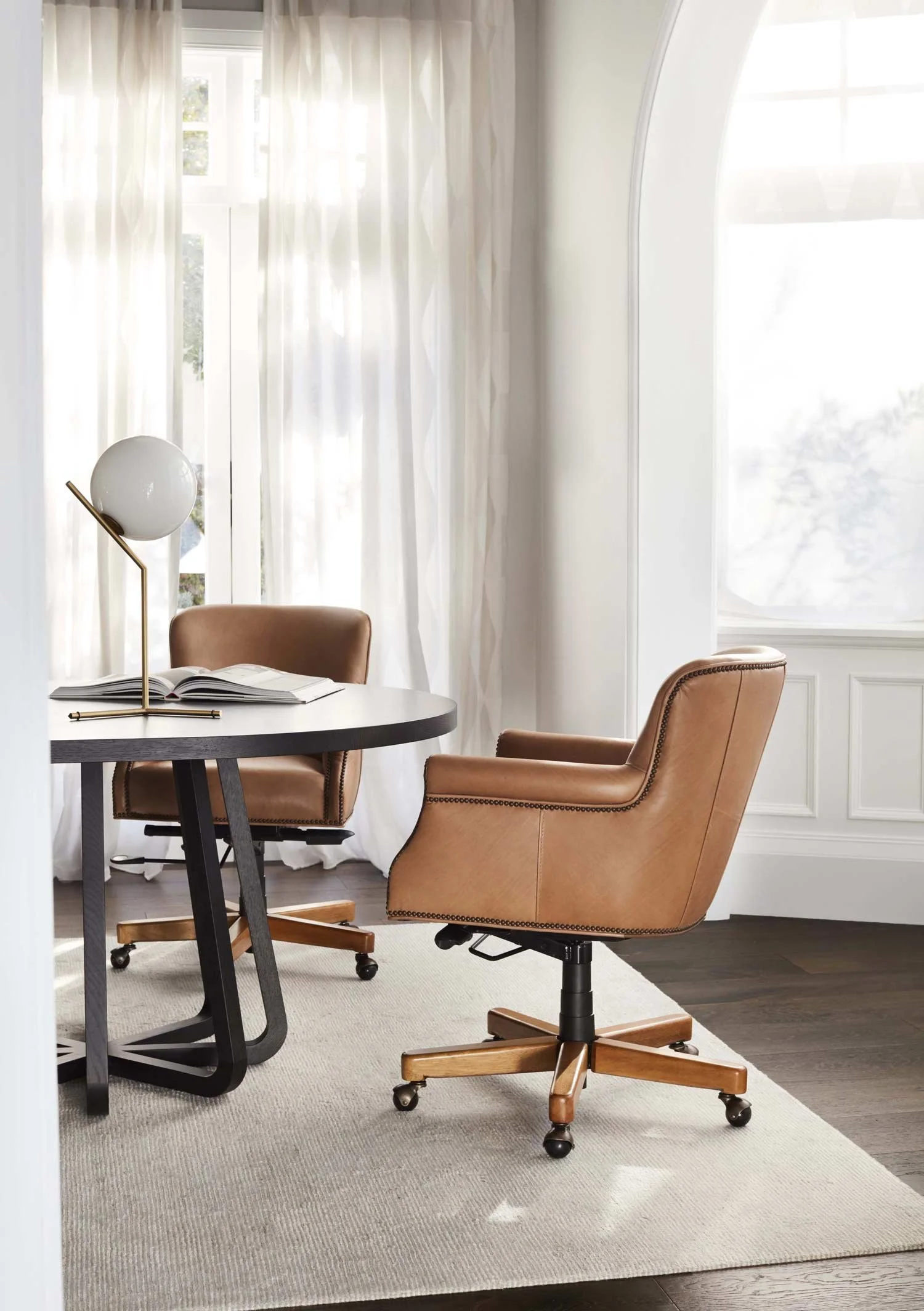 Two leather office chairs by a round black table