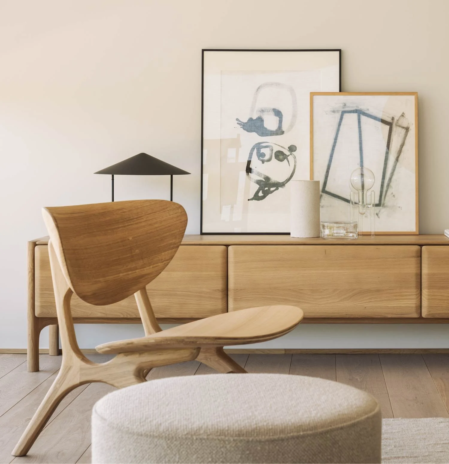 Living room with a modern wooden chair and abstract art in the background.