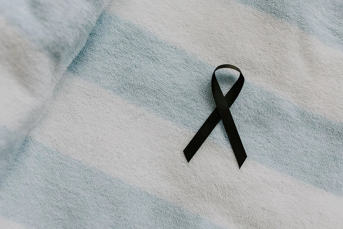 Black ribbon resting on a blue and white blanket