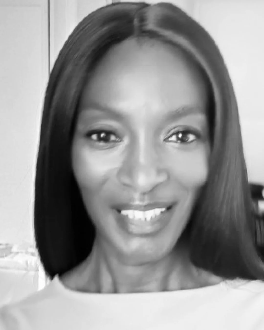 A smiling woman with straight shoulder-length hair, looking at the camera.