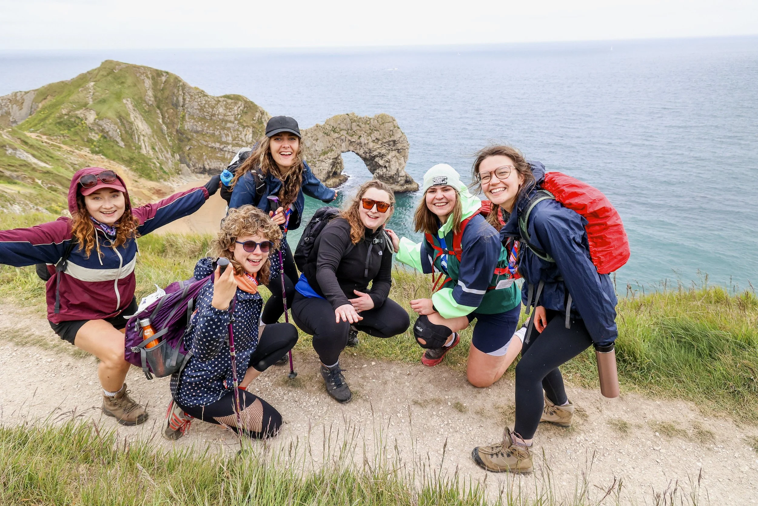 Group of fundraisers pose on cliff side walk on the jurassic coast