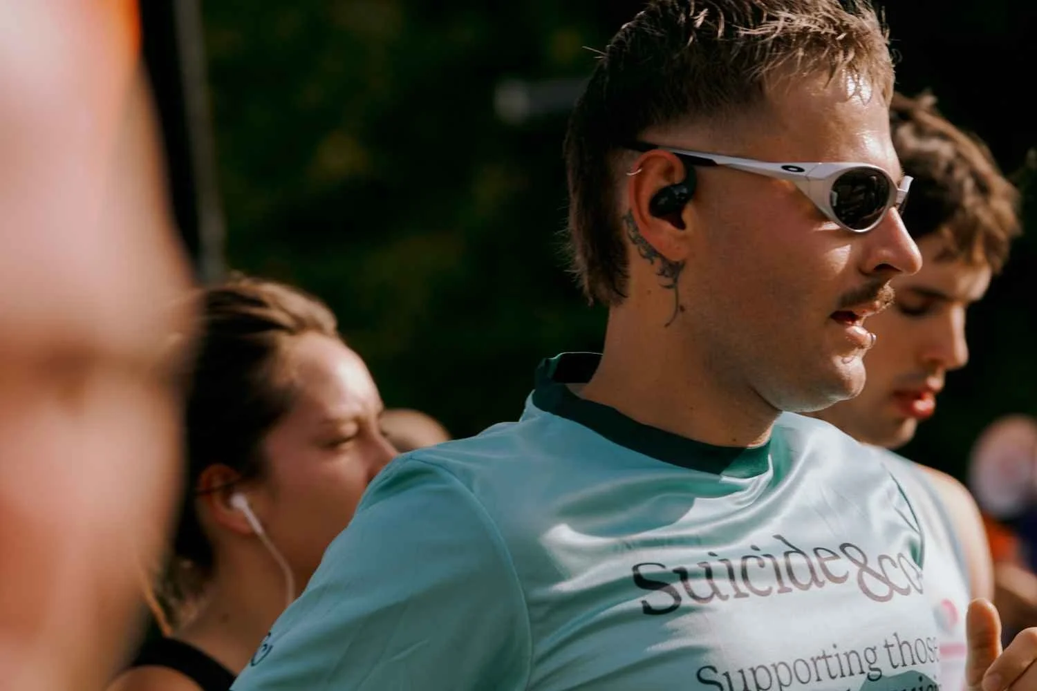 Close up shot of Suicide&Co runner mid race wearing sun glasses